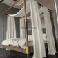 a four poster bed with white drapes on it