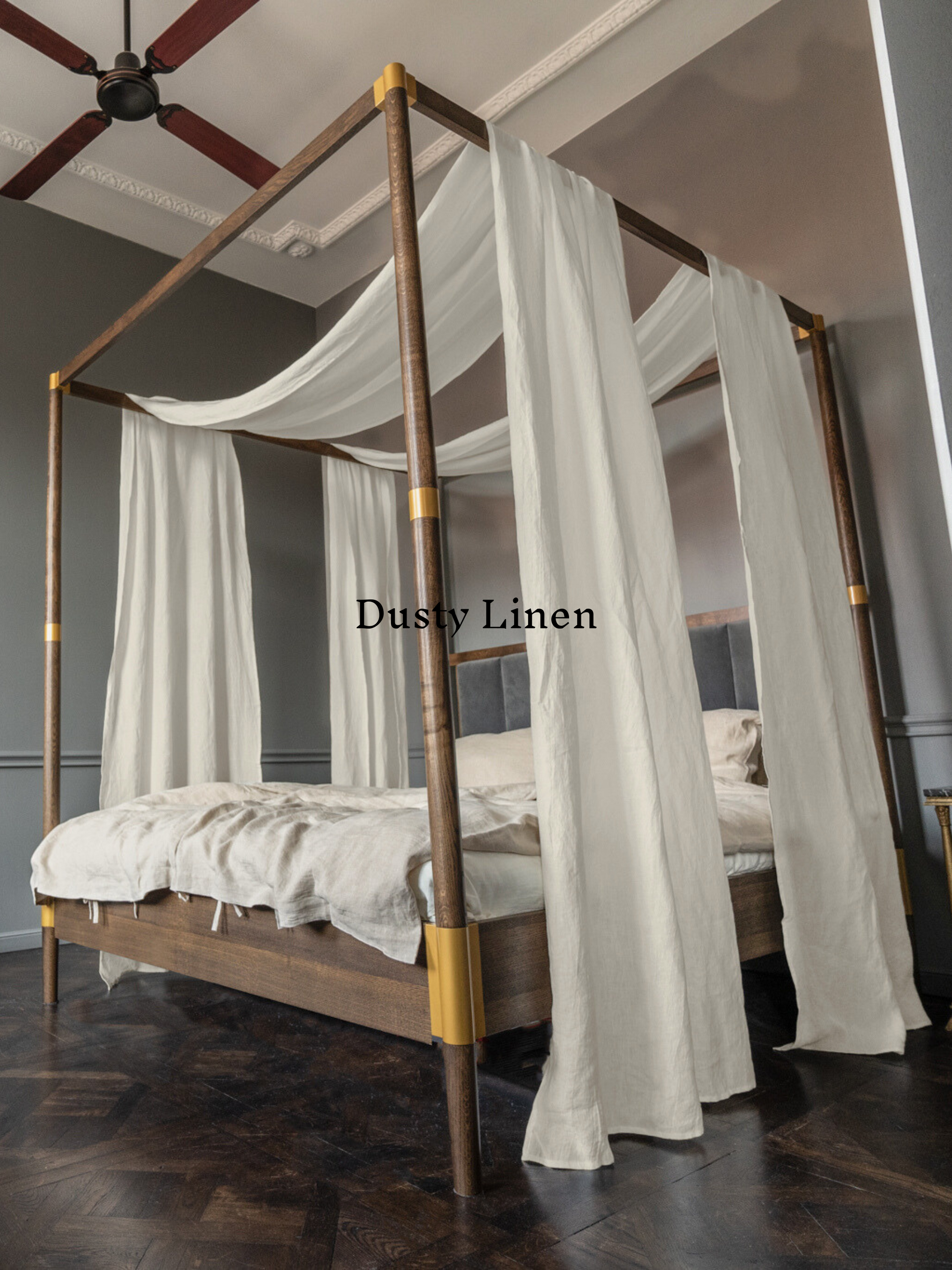 a four poster bed with white drapes on it