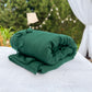 a bed with a green blanket on top of it