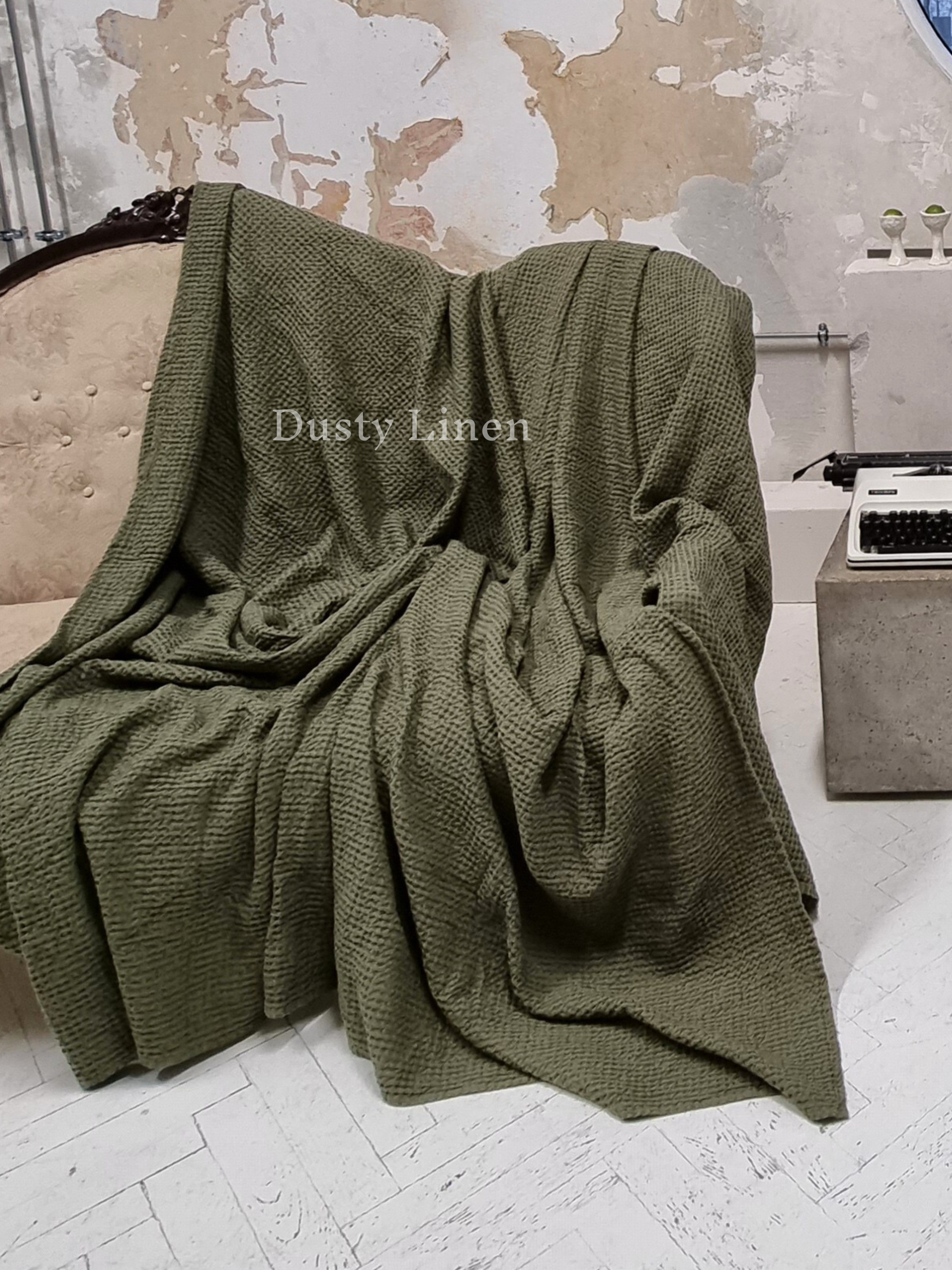 a green blanket sitting on top of a white floor