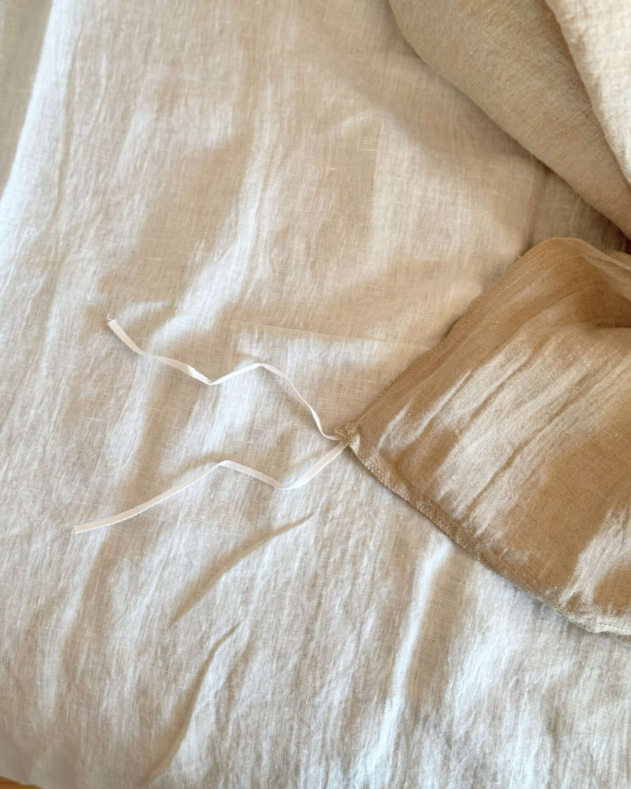 Minimalist linen duvet cover on bed near window, natural light
