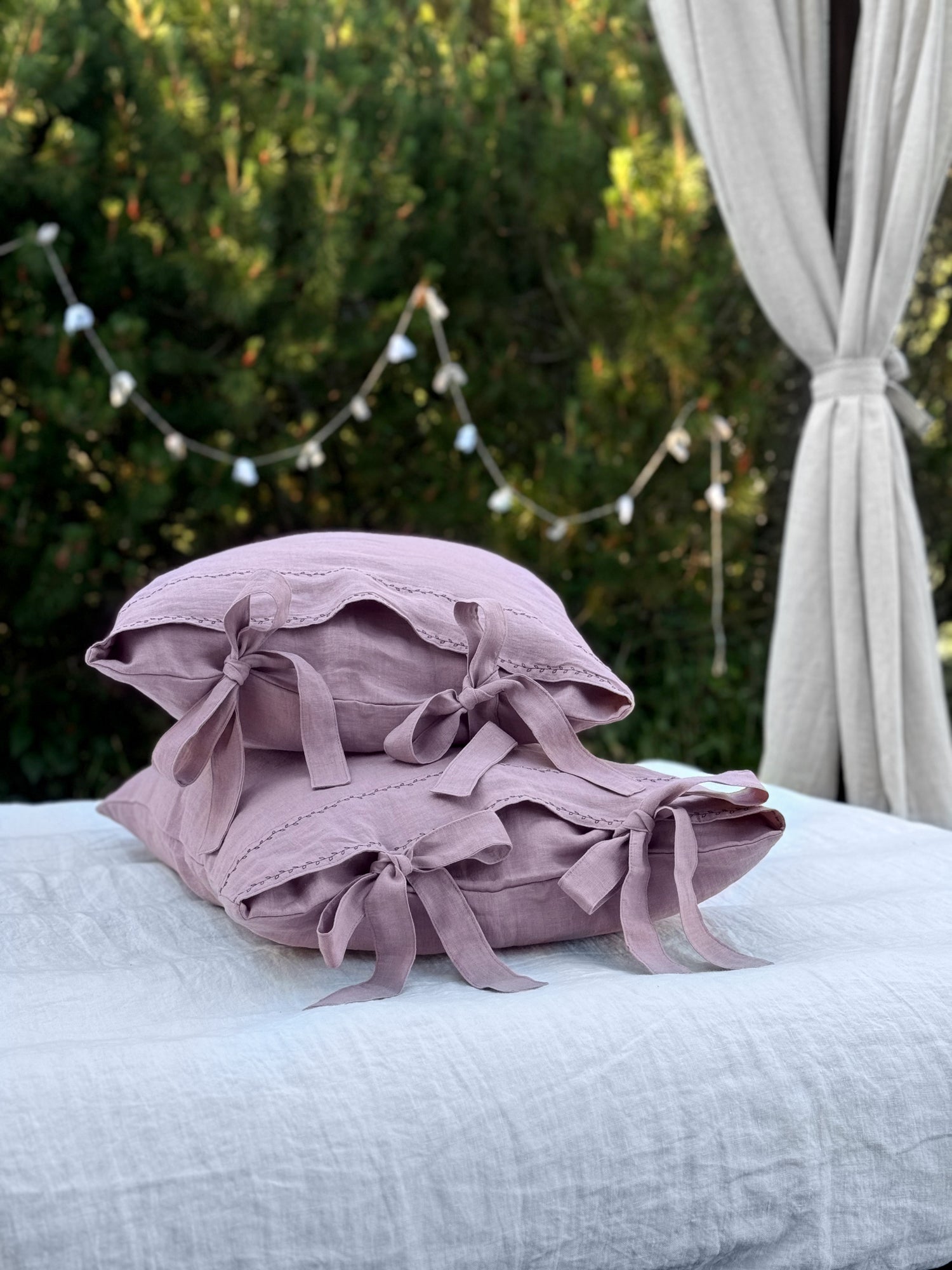 Dusty rose black embroidered linen pillowcase on white bed linen
