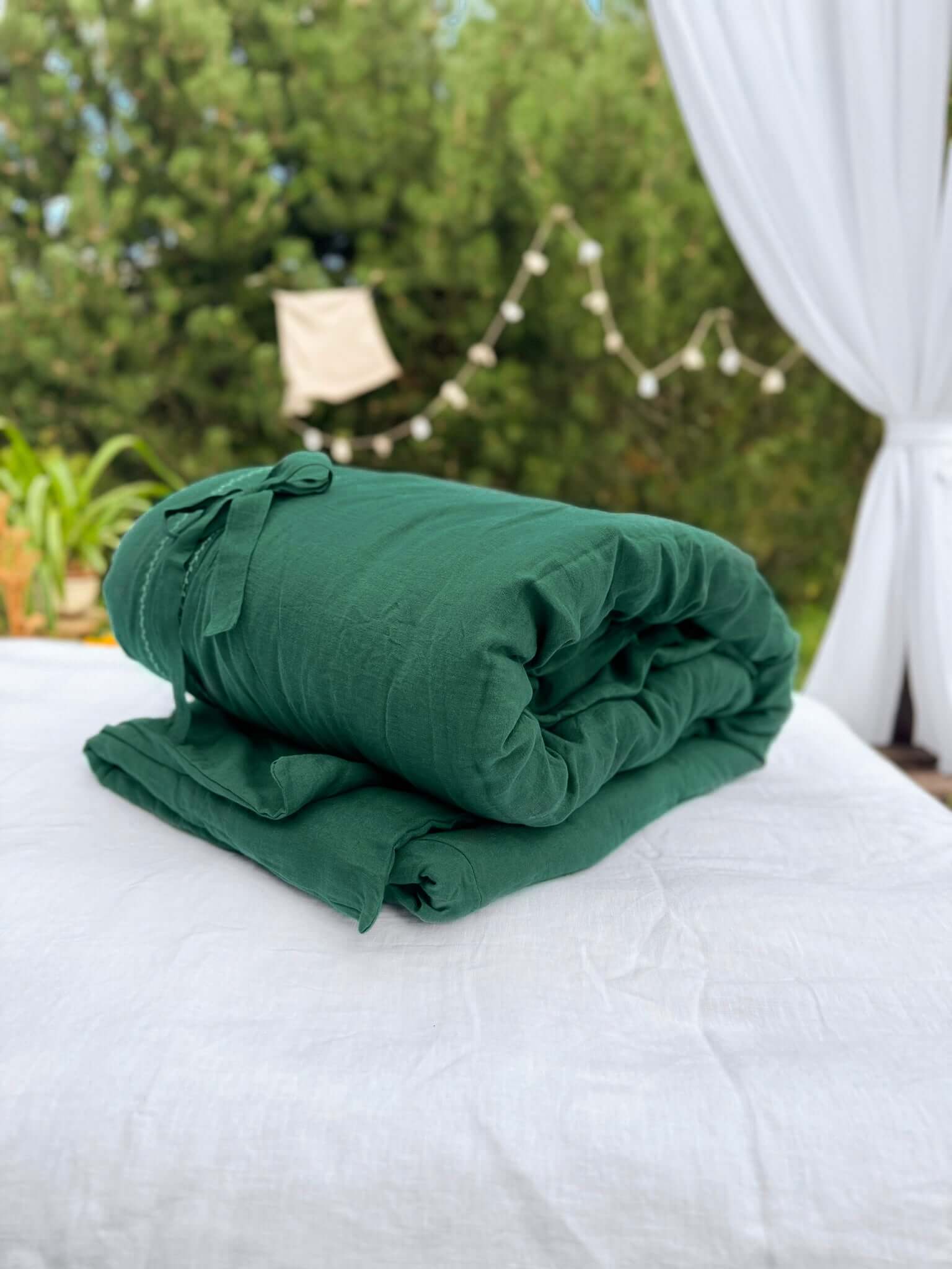 White embroidered linen bedding set with sage green accent pillow