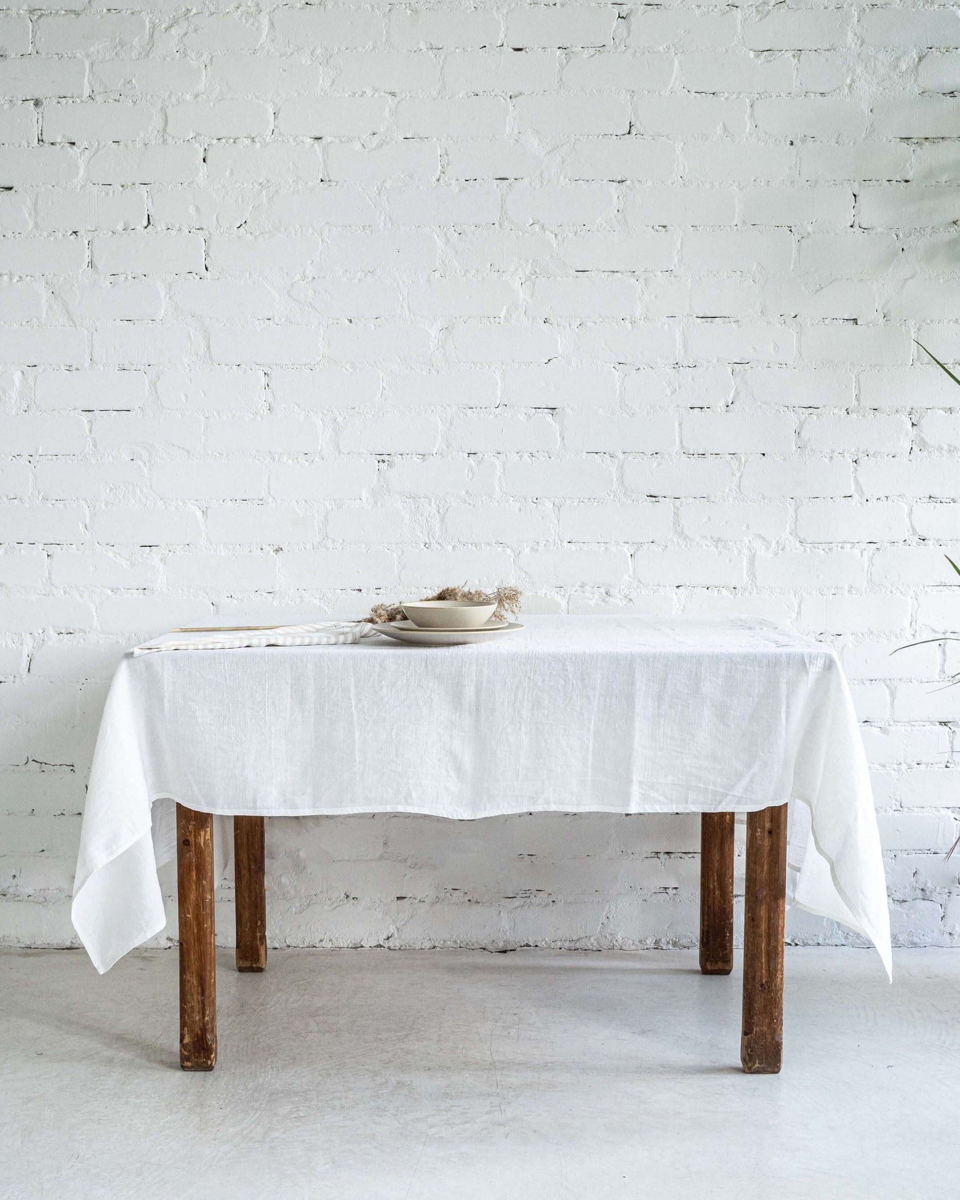White linen tablecloth on simple dining table, minimal setting