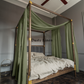 a four poster bed with a green canopy