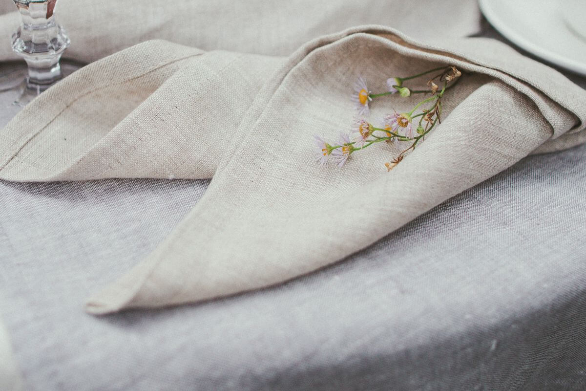 Folded white linen napkin on table, minimalist bedroom styling