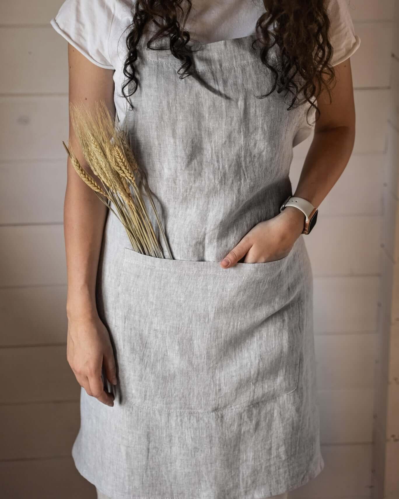 Woman wearing linen apron outdoors in garden setting