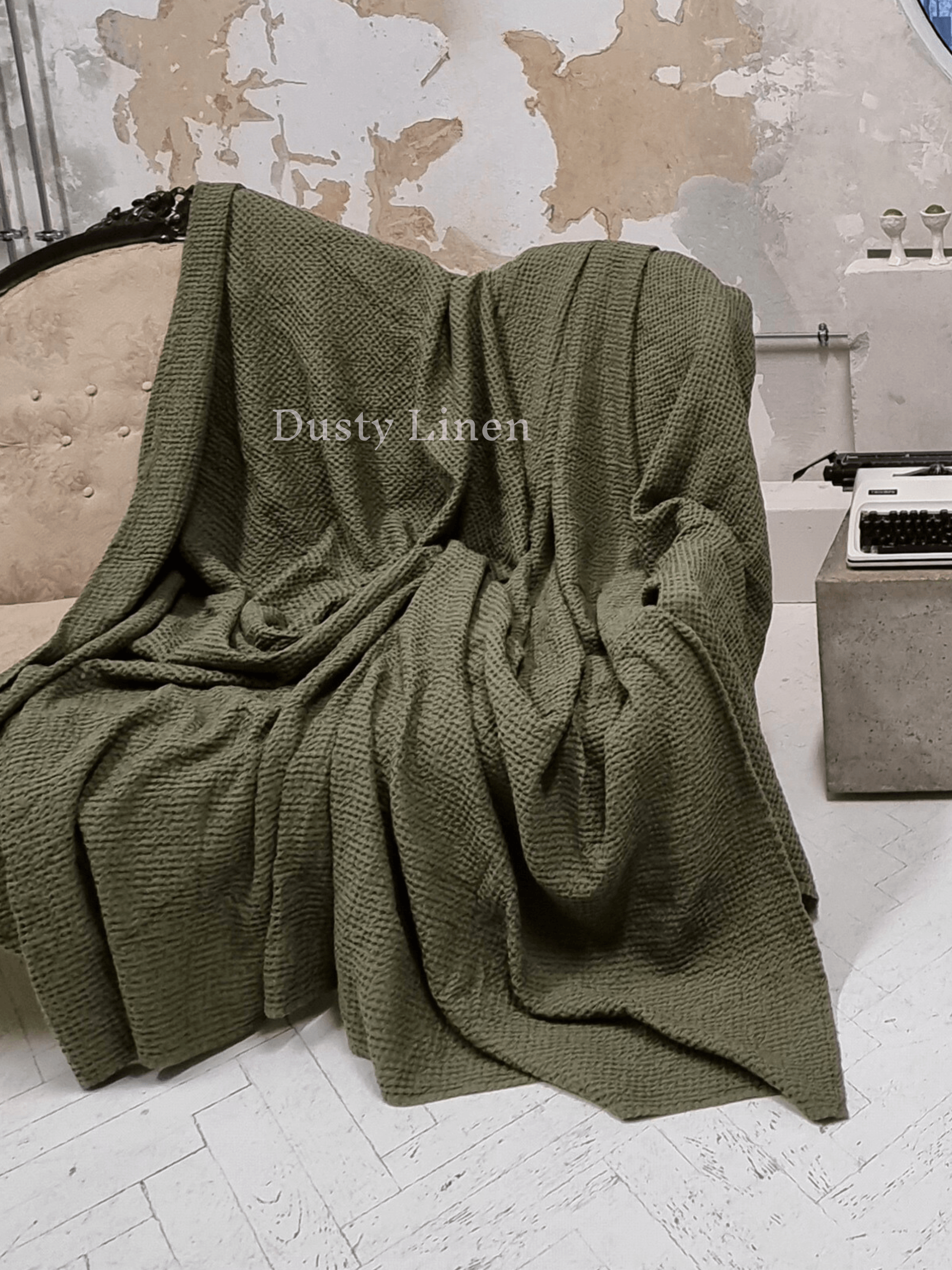 Large waffle blanket khaki green — folded on white floor