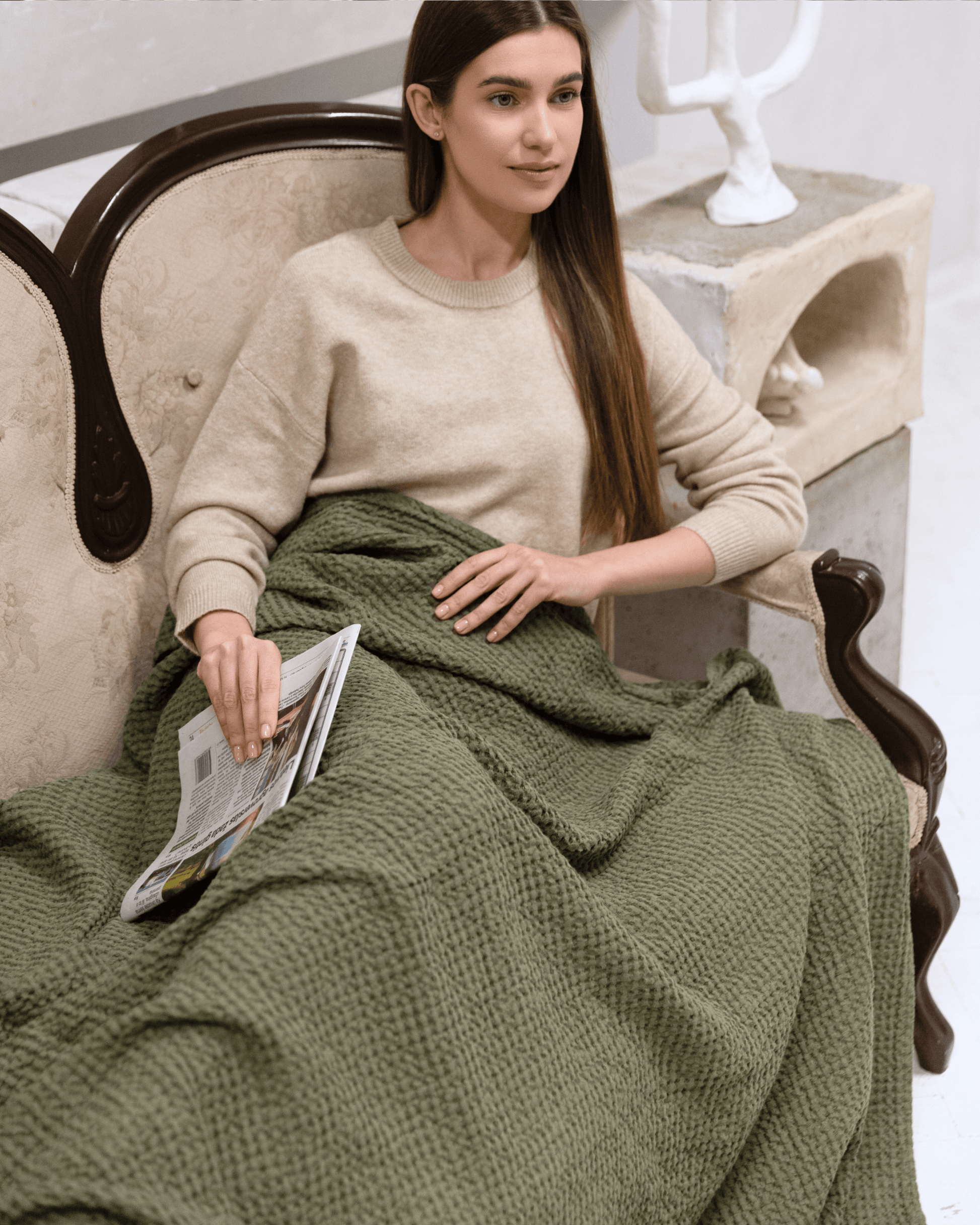 Large waffle blanket khaki green — woman wrapped in blanket in armchair