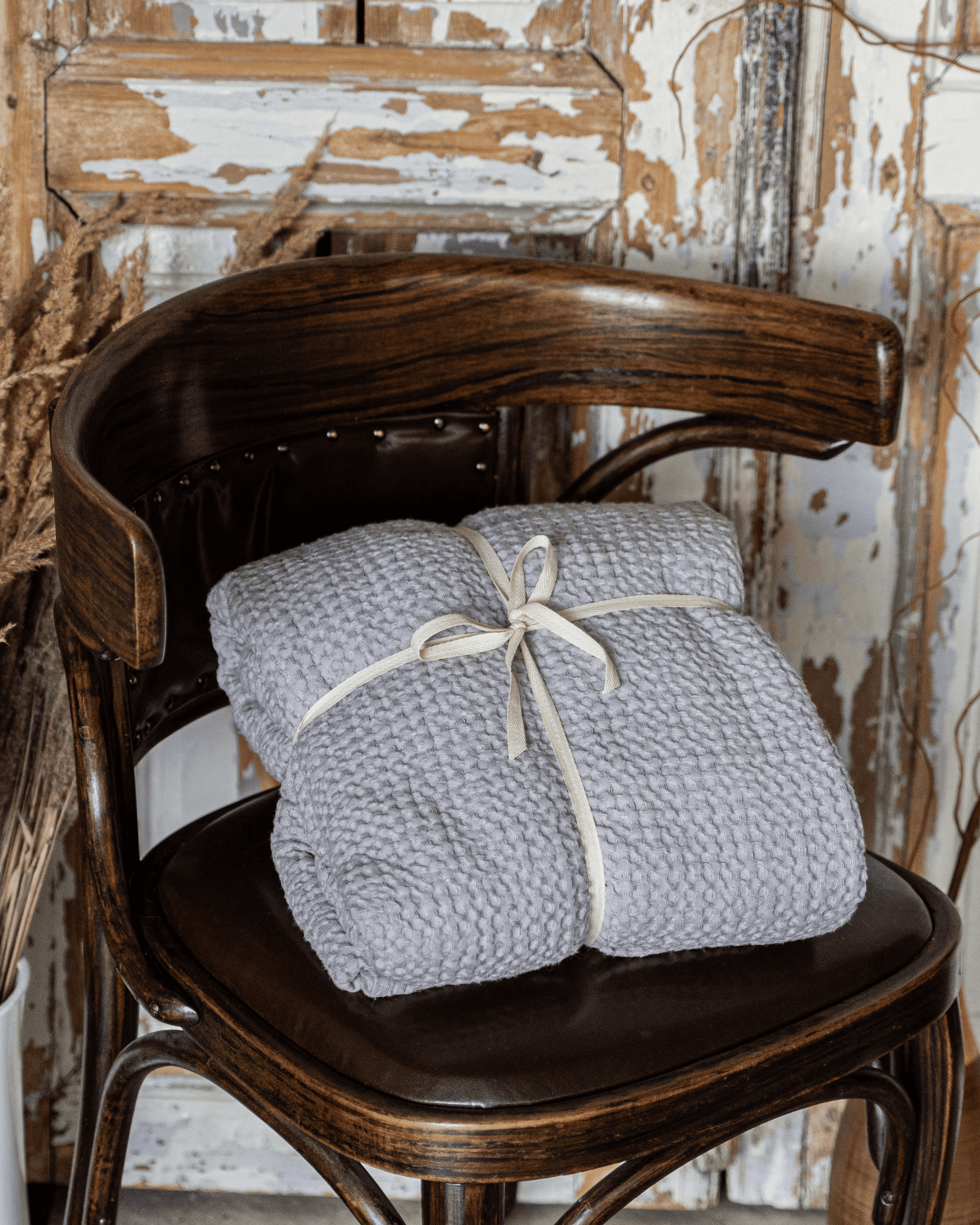Large waffle blanket light grey - draped over armchair with linen pillows