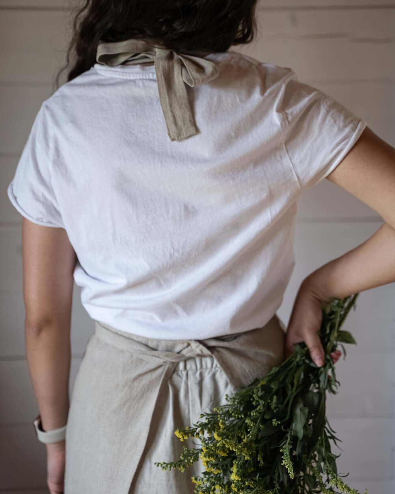 Woman wearing linen apron in kitchen, lifestyle photo