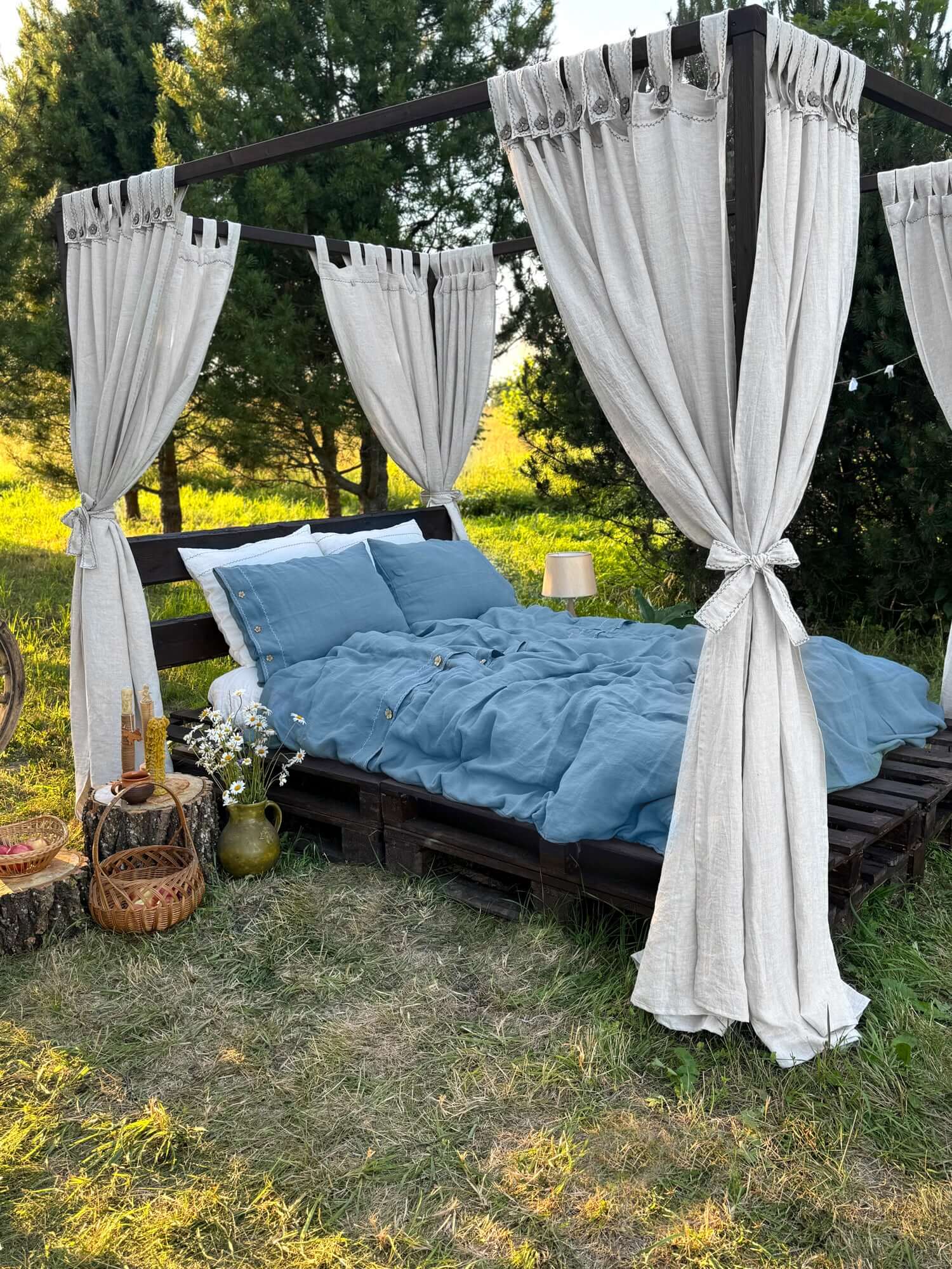 Linen canopy bed curtains with button tab tops on outdoor four-poster bed, white