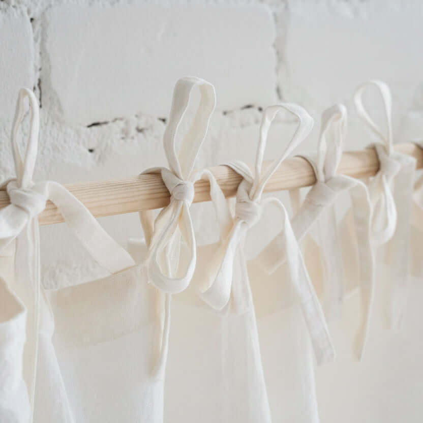 Close-up of linen curtain tie top ribbons attached to a curtain rod