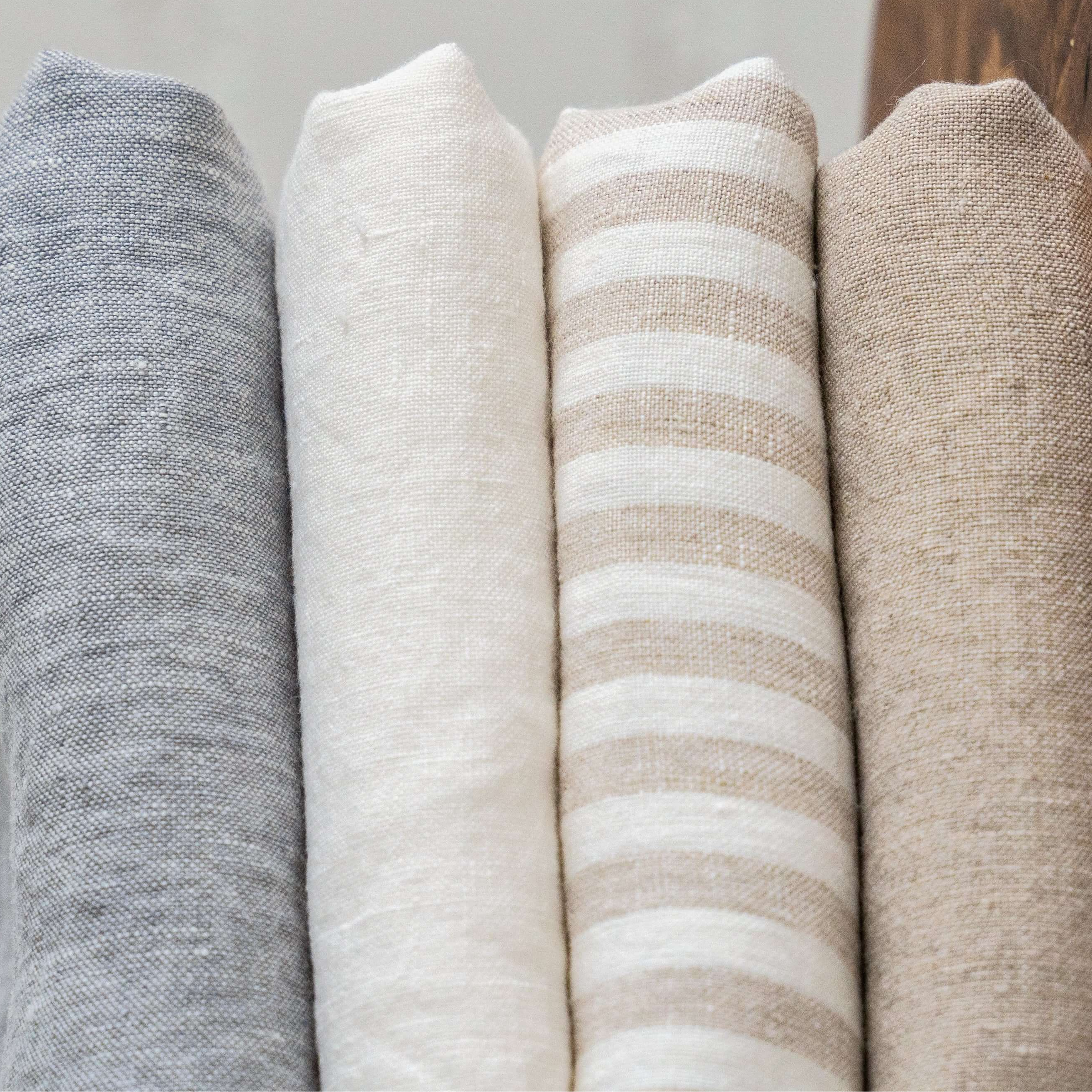 Stack of neutral linen fabric samples showing different textures and tones