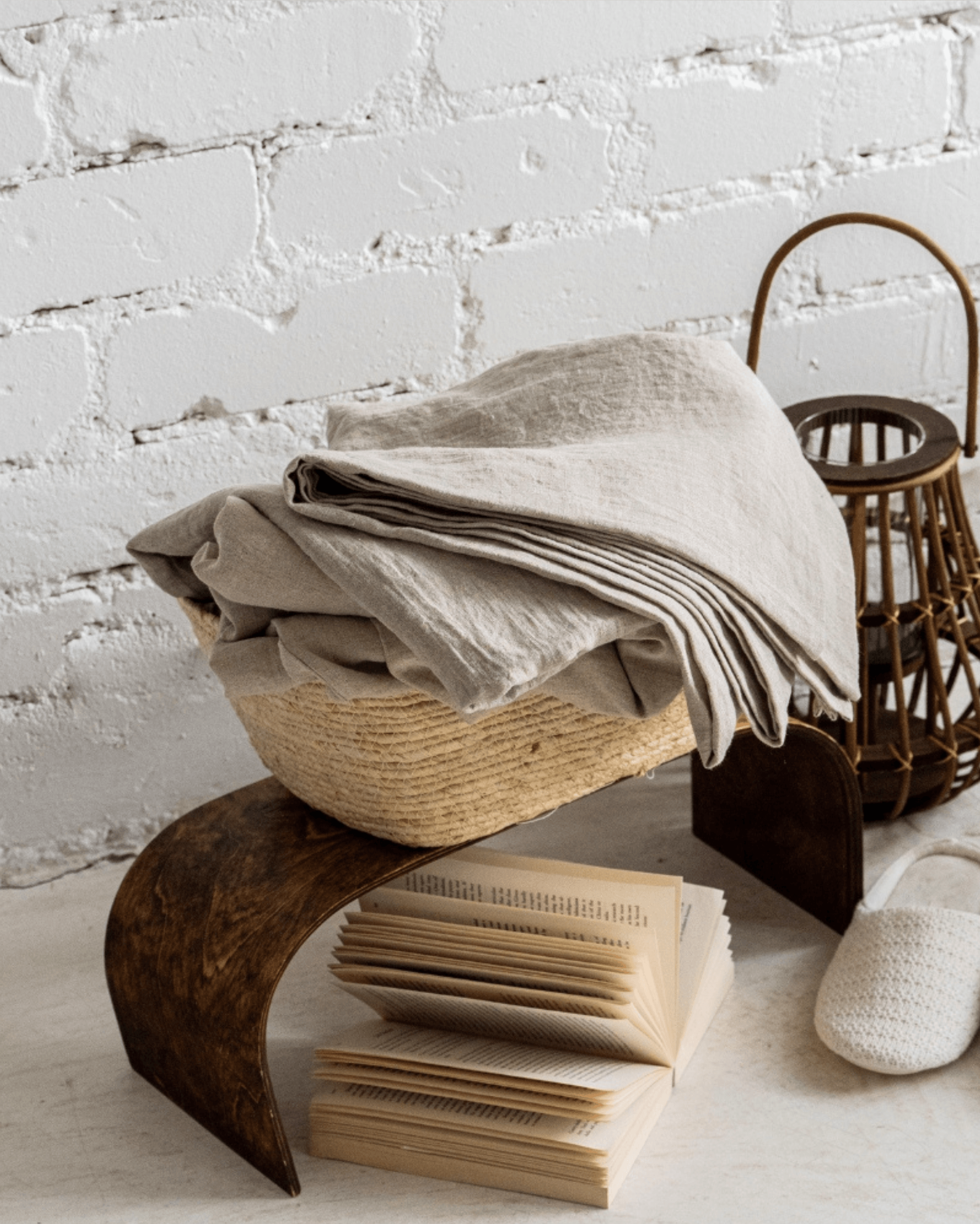 Folded linen flat sheet on wooden surface, softened linen texture visible