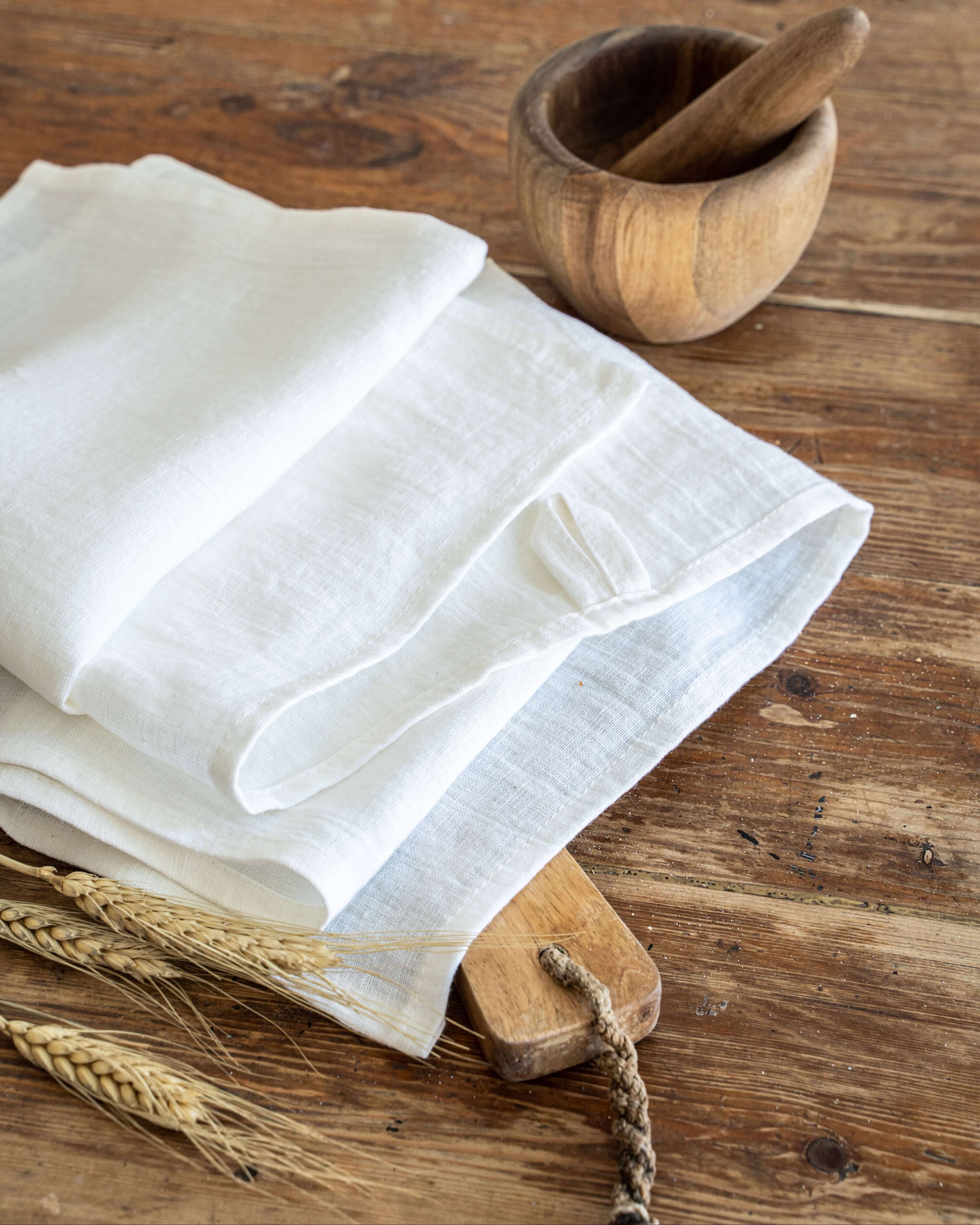 Linen tea towel folded on wooden surface, softened linen texture