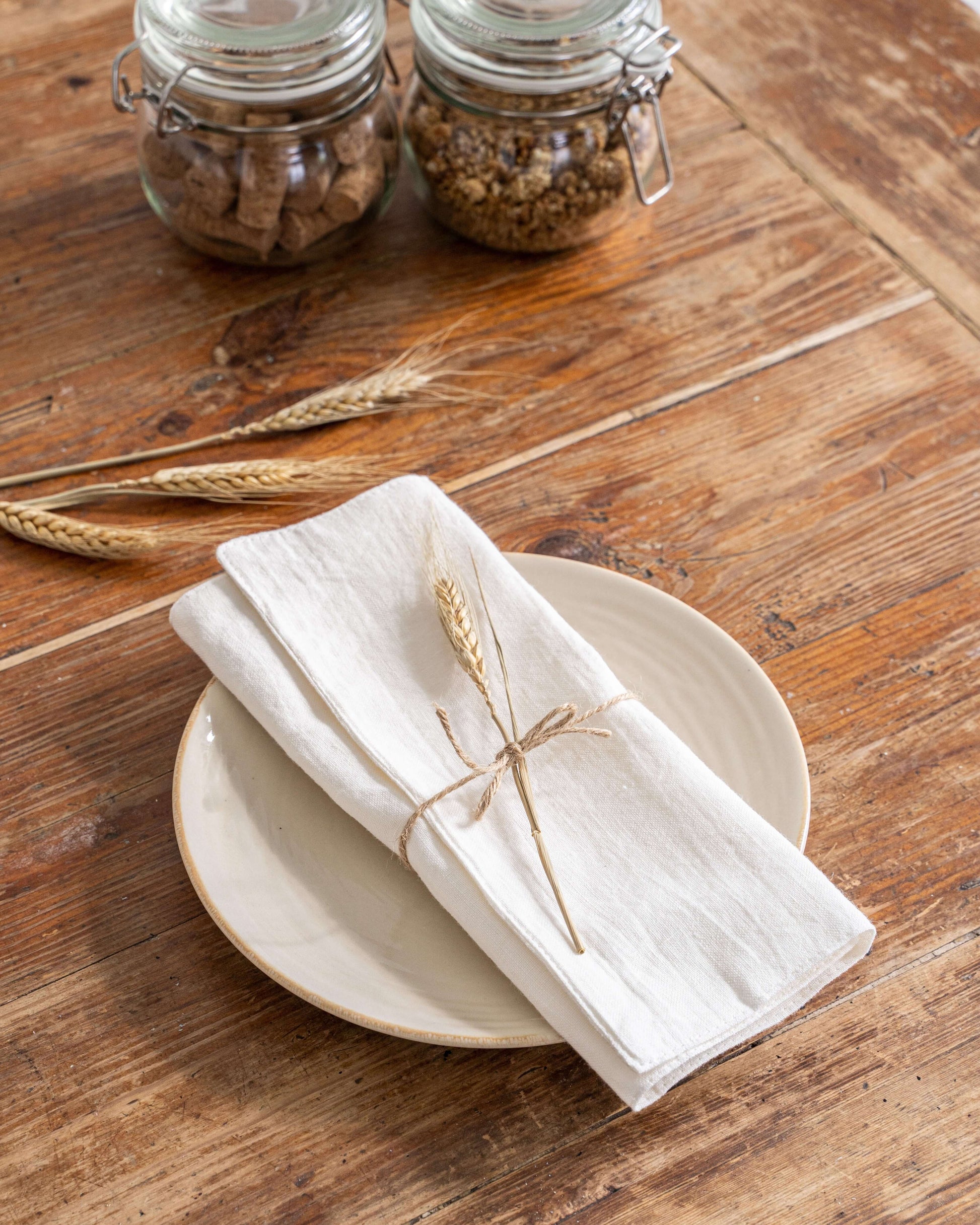 Linen placemat in natural tone with food setting on wooden table