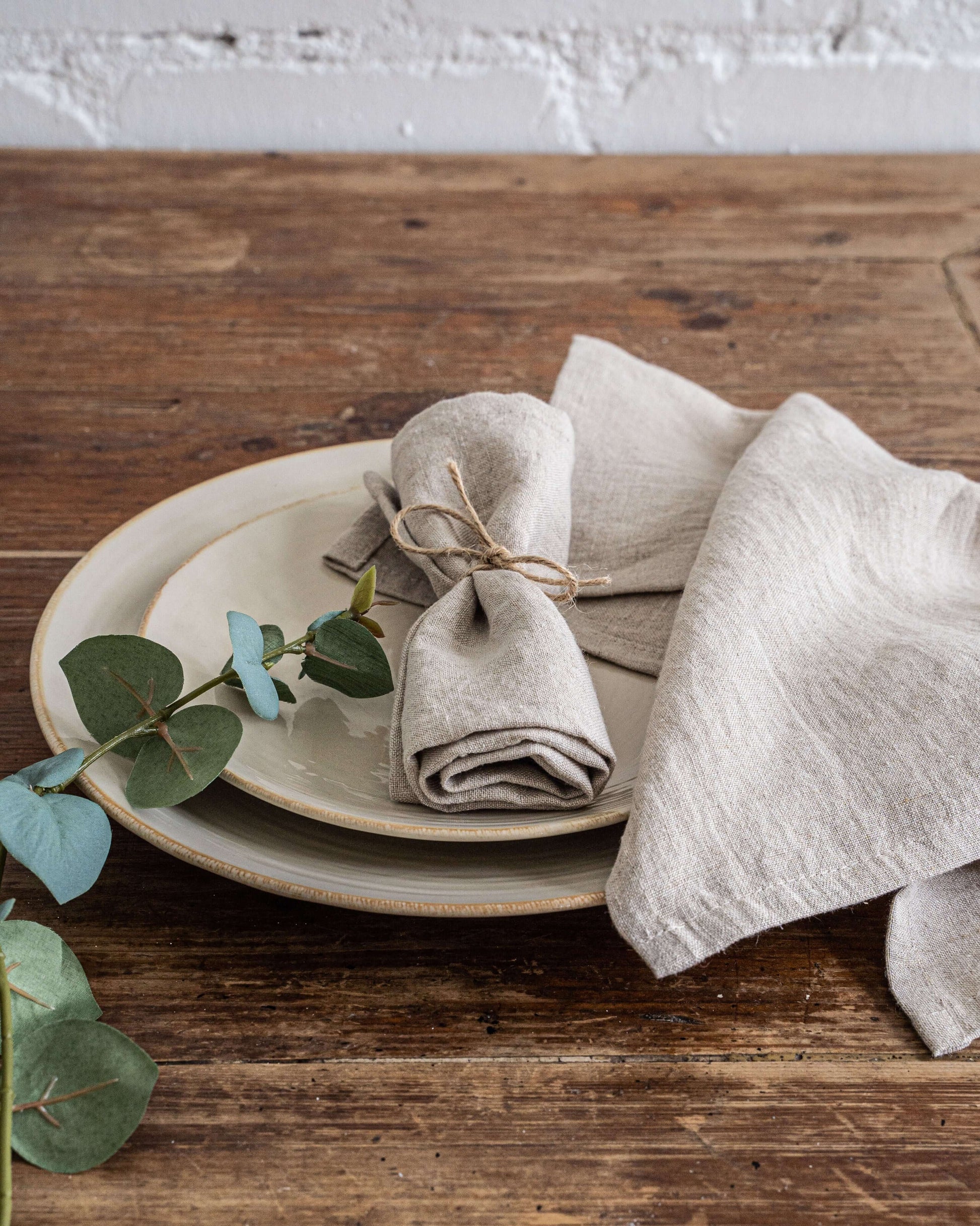 Linen napkins styled with rustic tableware on wooden table