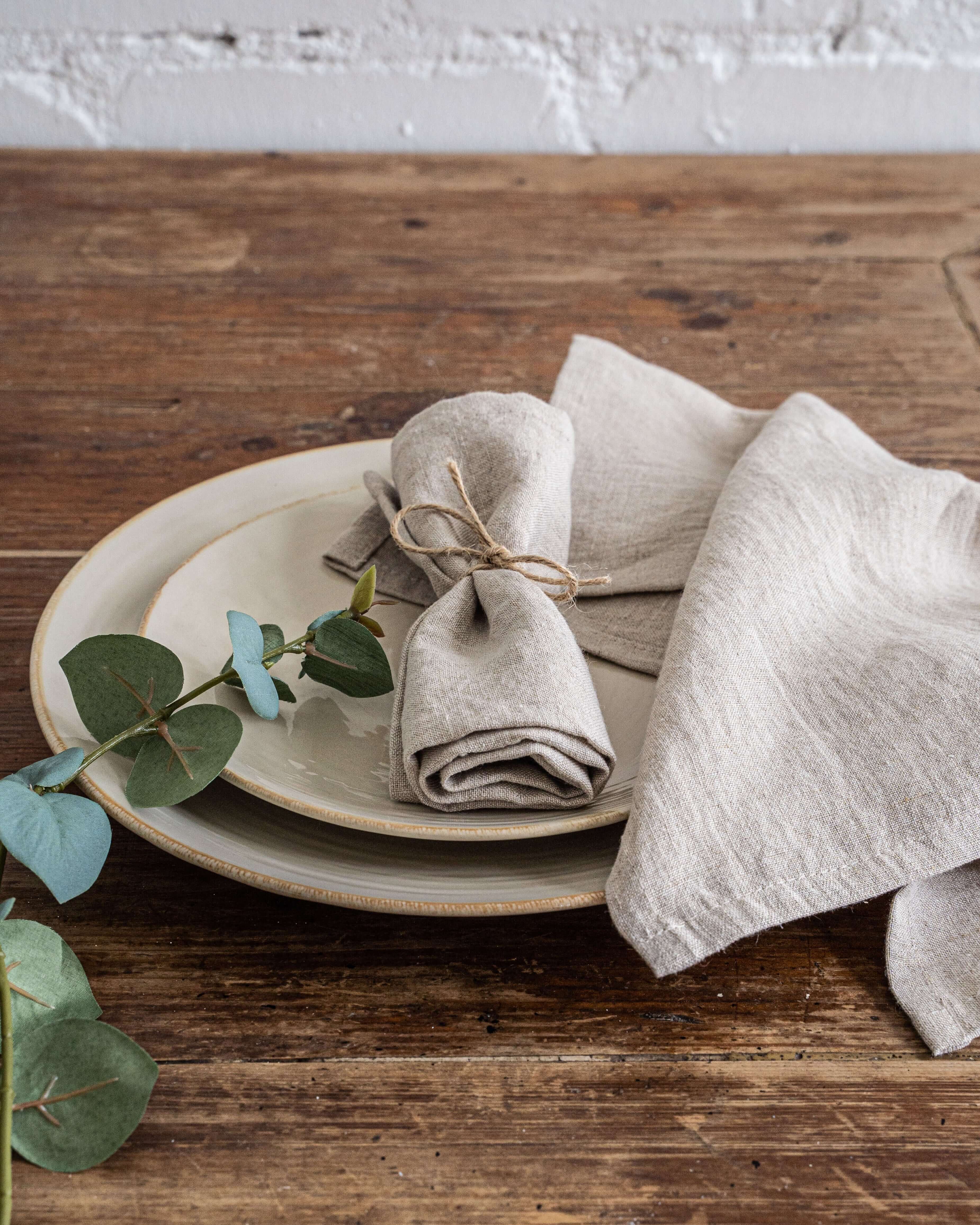 Linen napkins styled with rustic tableware on wooden table