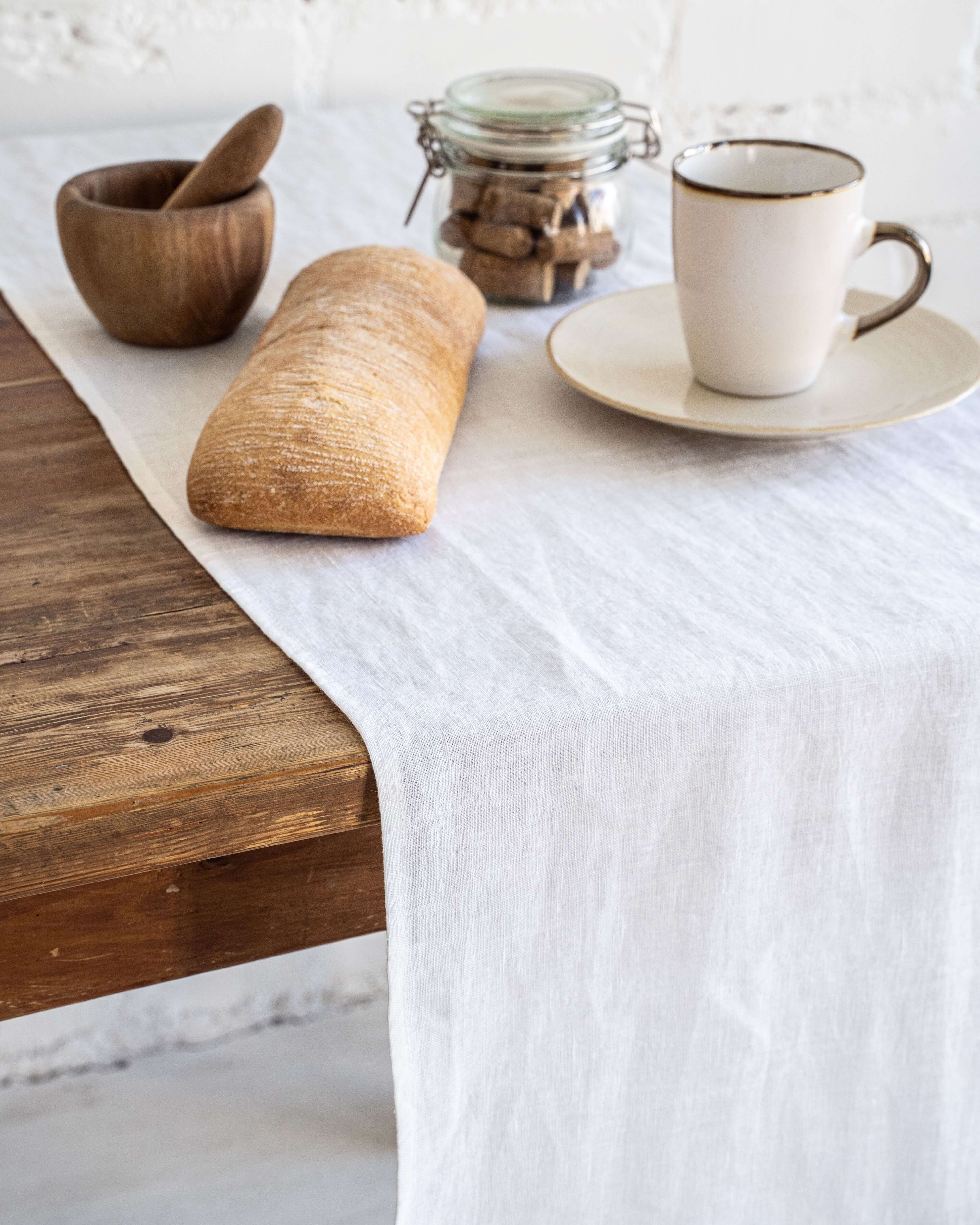 Linen table runner in natural tone, folded close-up showing texture