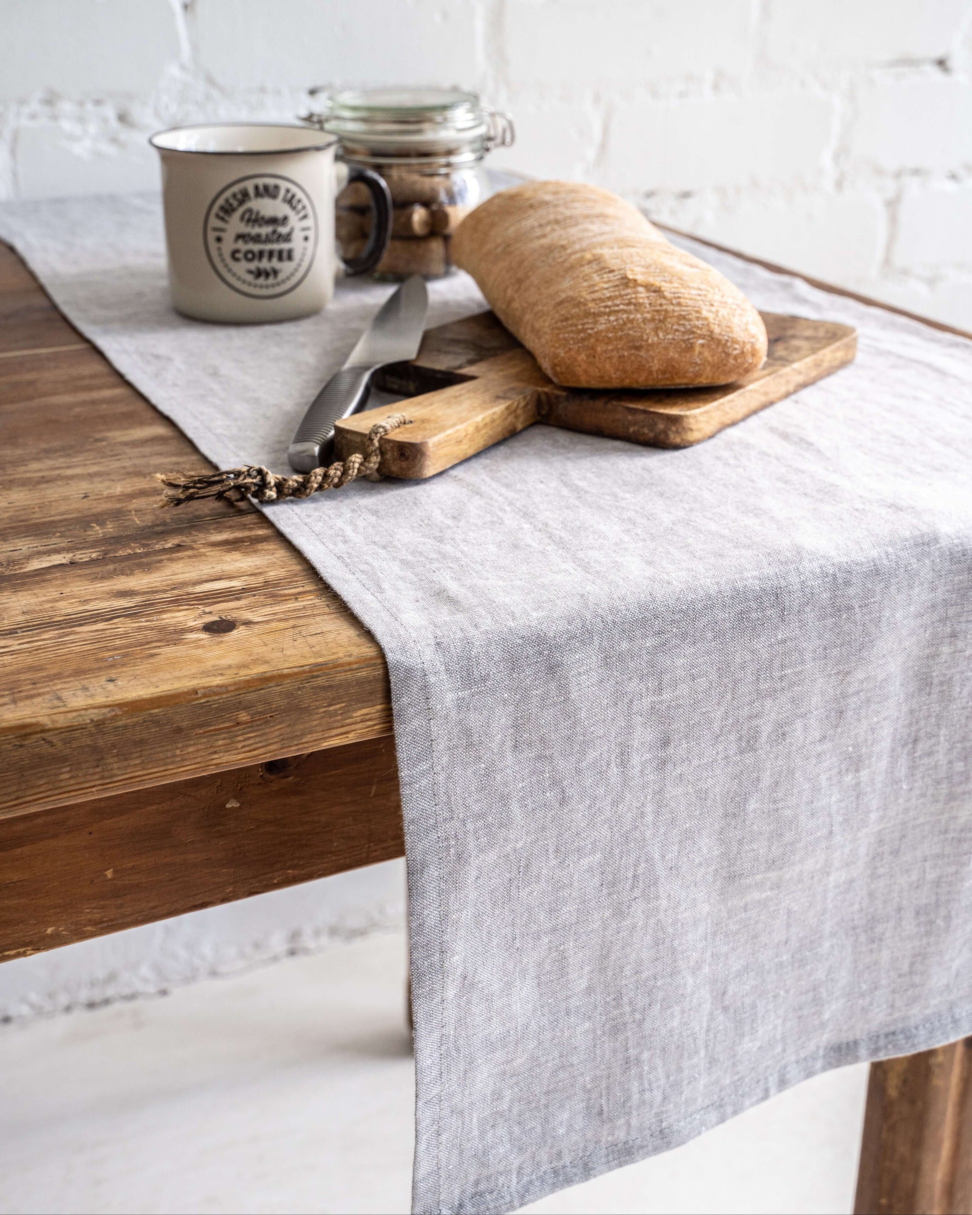 Linen table runner with ceramic tableware on dining table