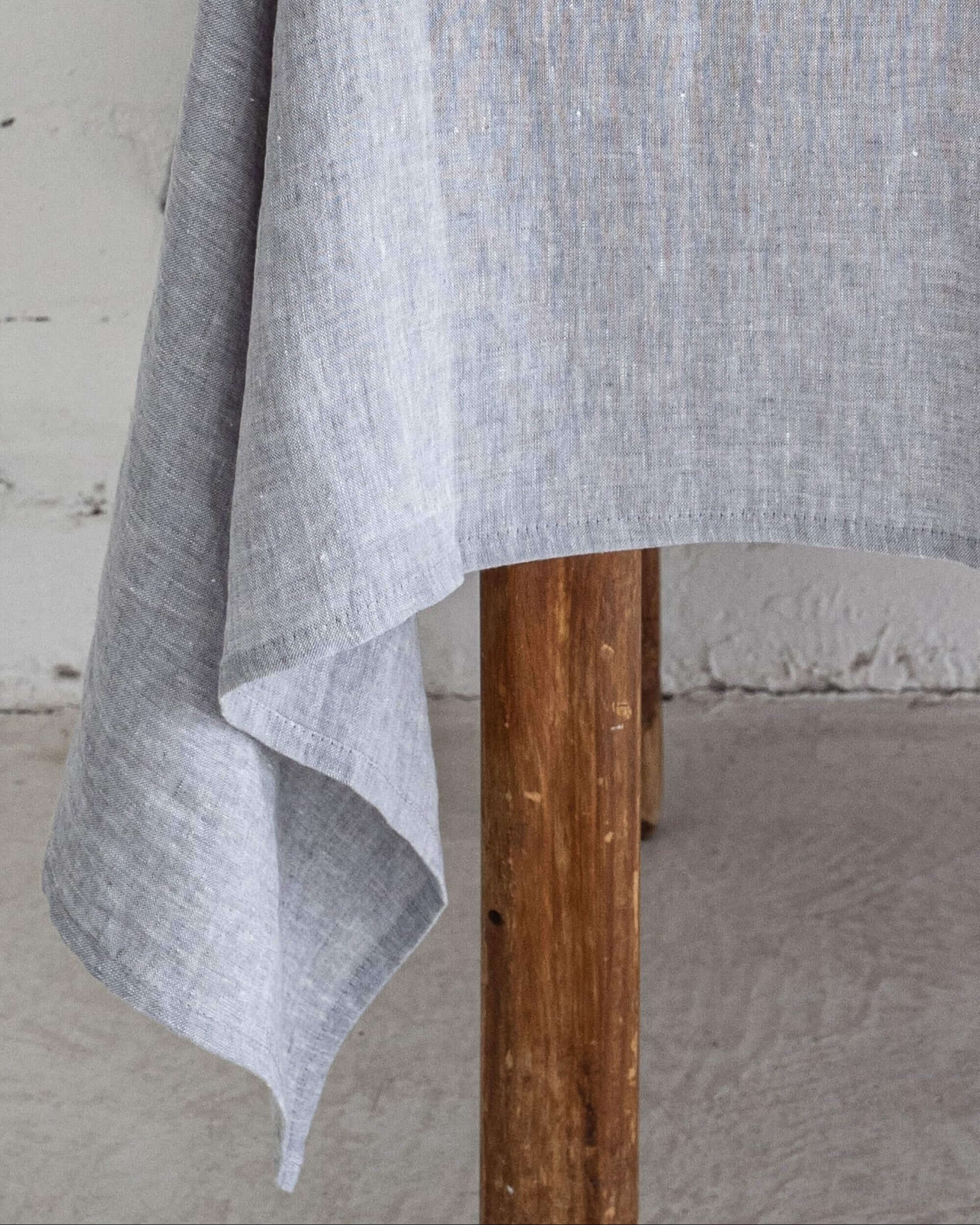 Natural linen tablecloth on long dining table, side view