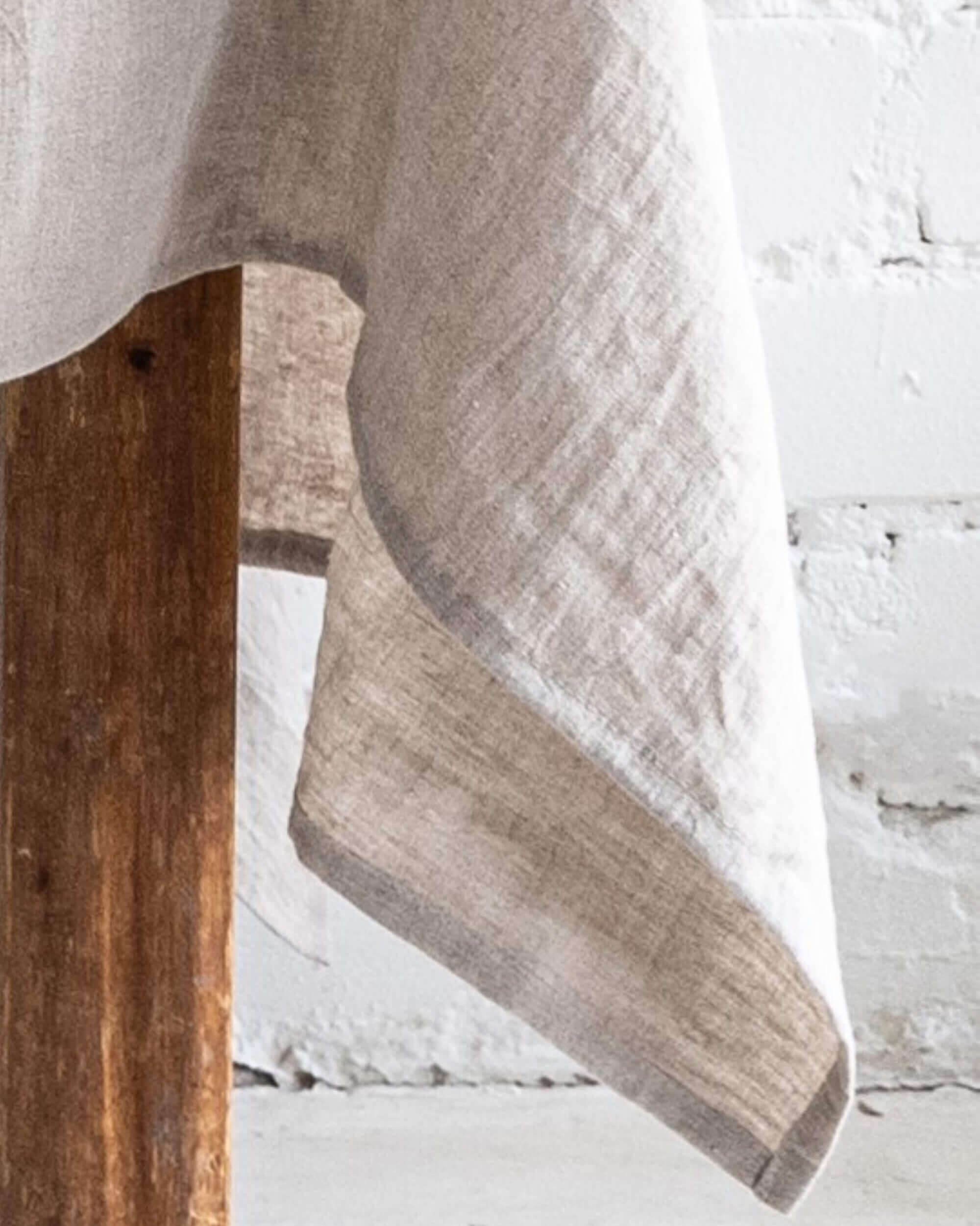 Person standing near linen tablecloth, showing drape and length