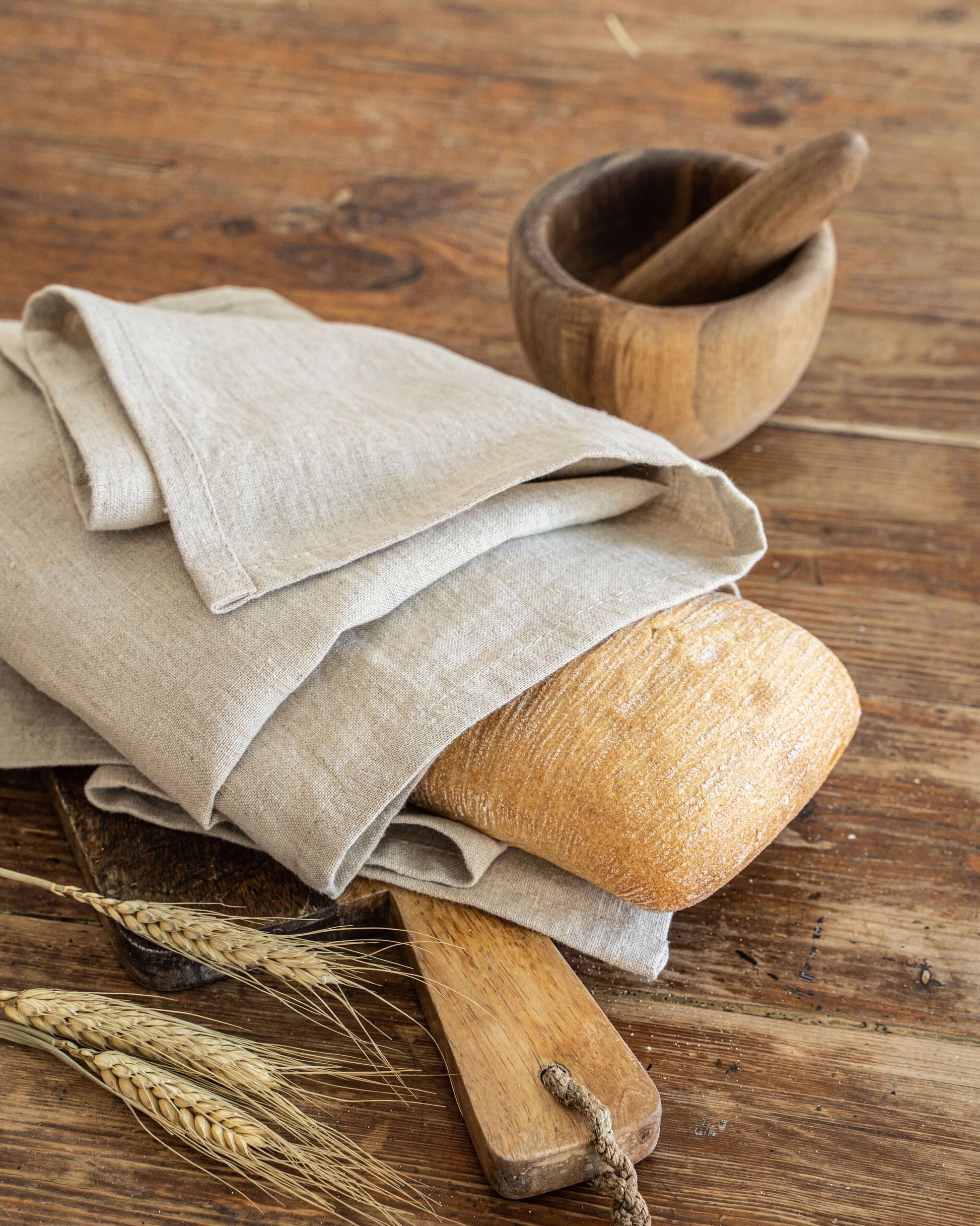 Linen tea towel in natural tone draped over wooden kitchen prop