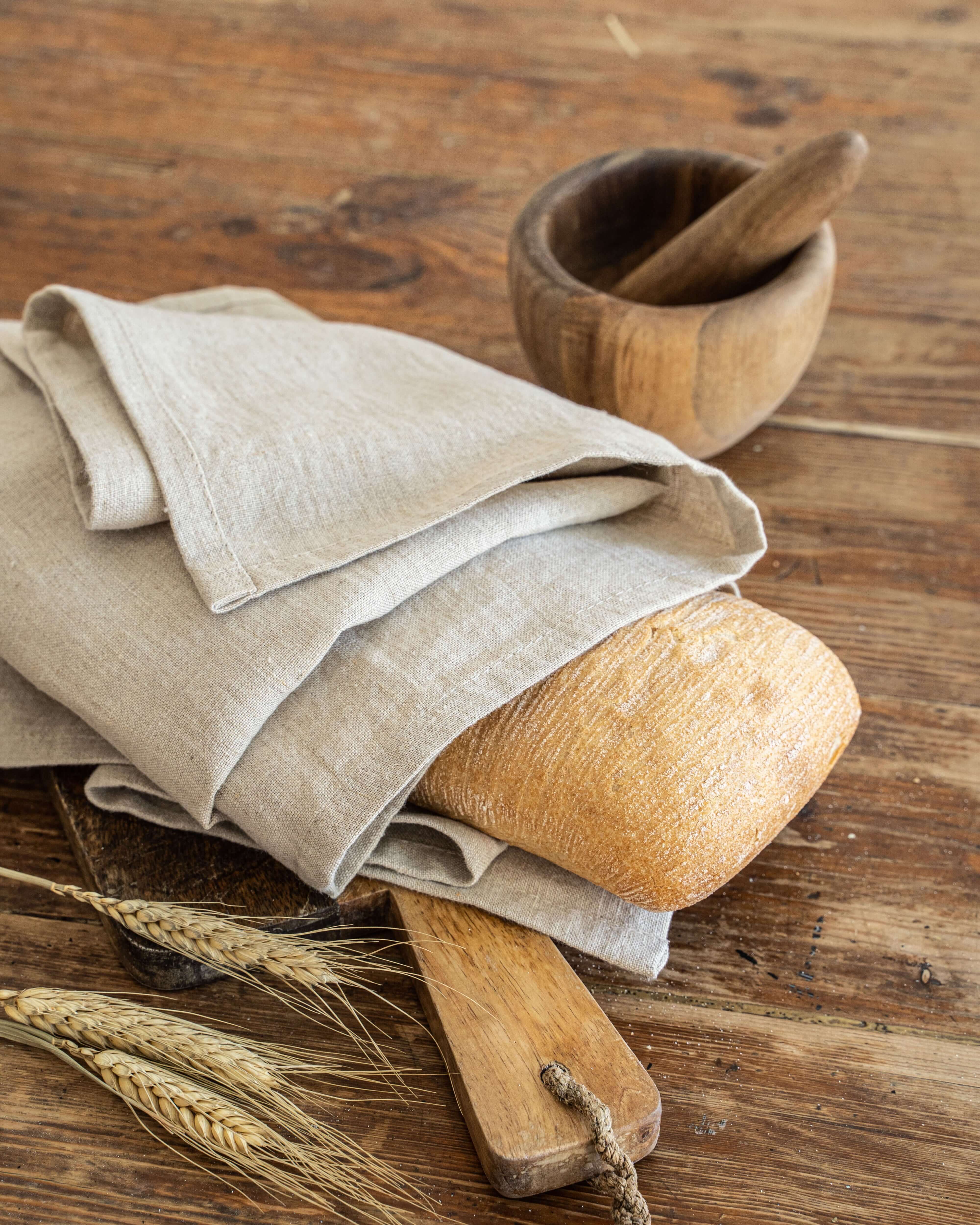 Linen tea towel in natural tone draped over wooden kitchen prop