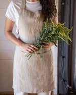 Linen apron in natural tone, front view, waist tie detail