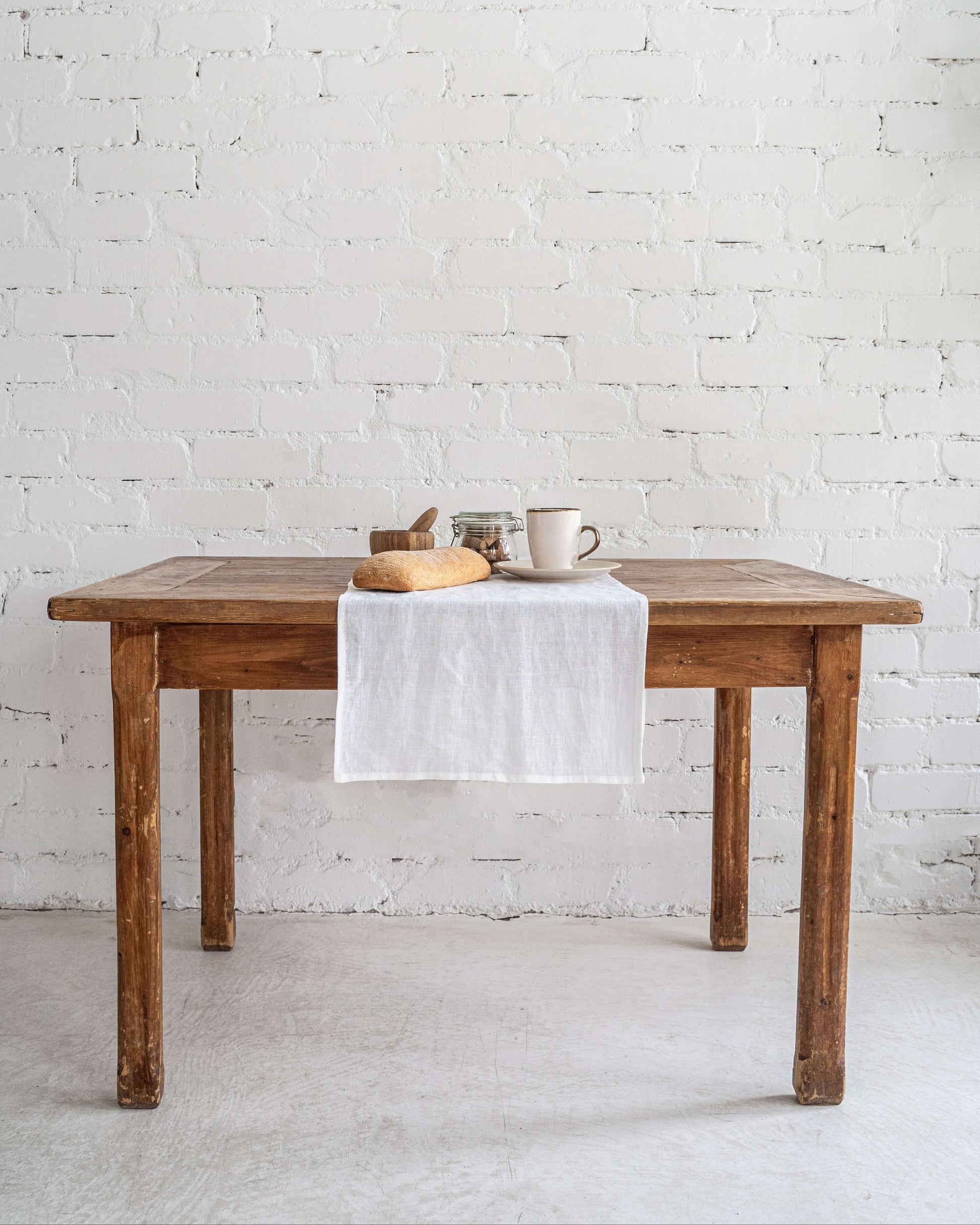 Linen table runner on wooden dining table, minimal styling