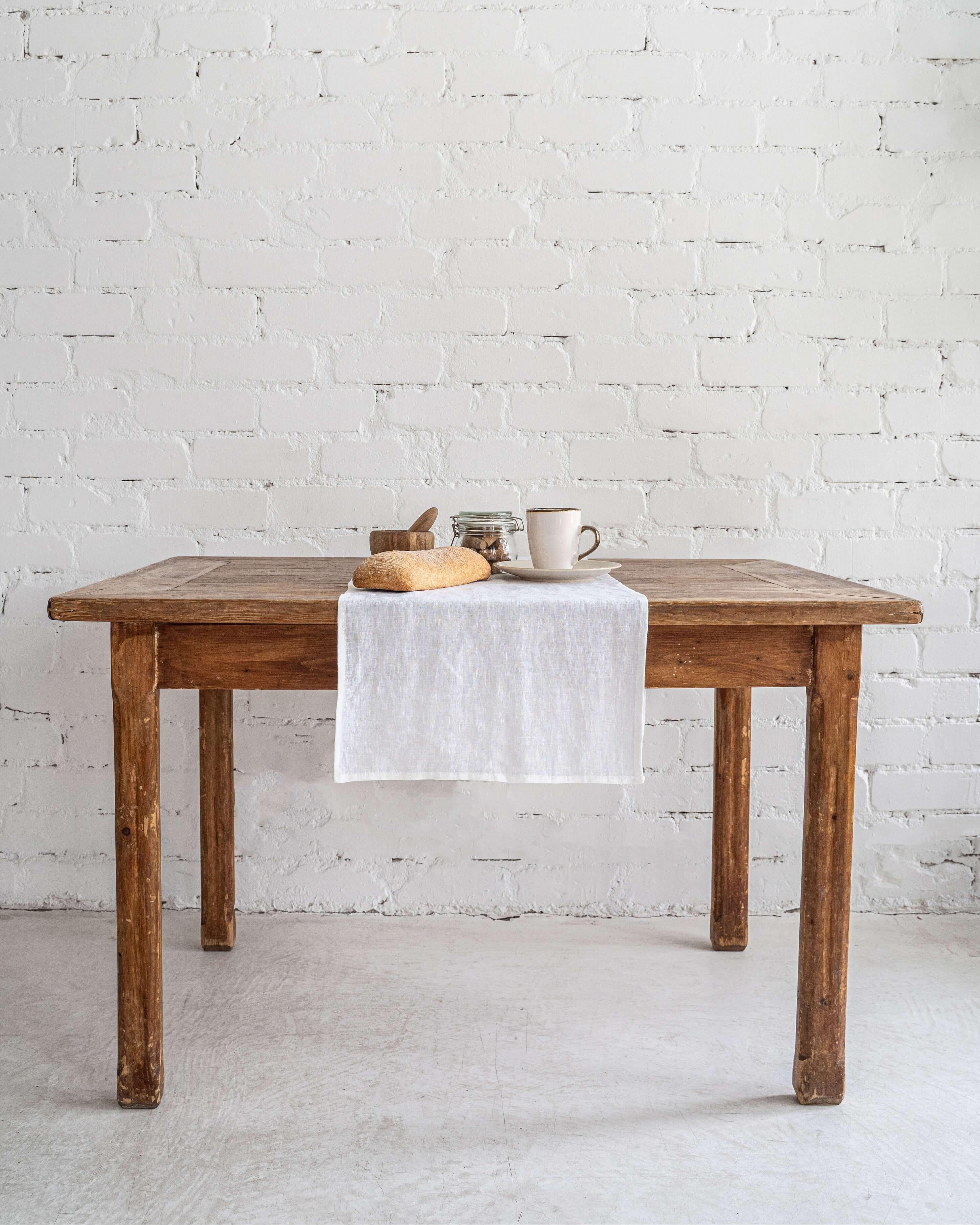 Linen table runner on wooden dining table, minimal styling