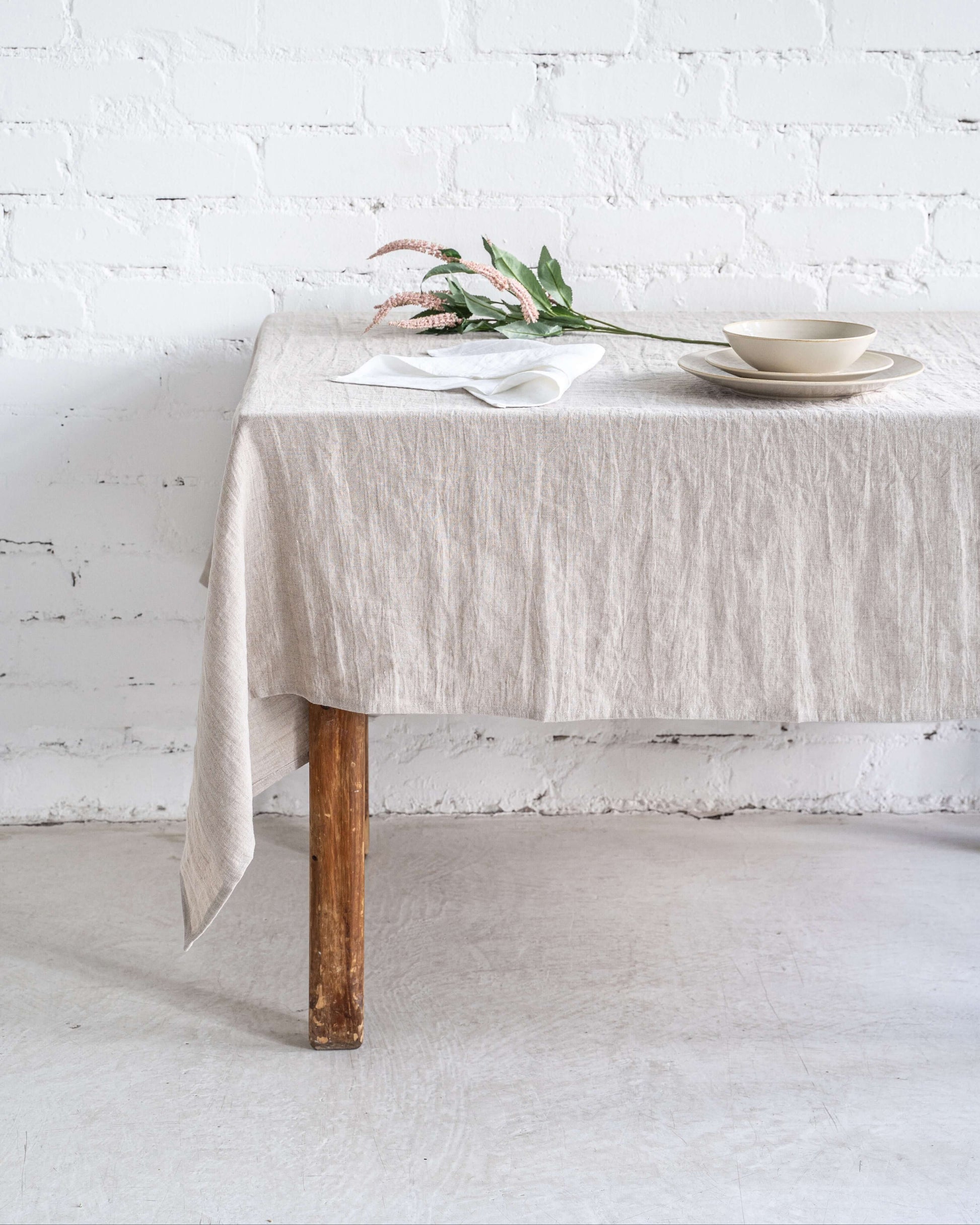 Linen tablecloth with natural overhang on wooden dining table