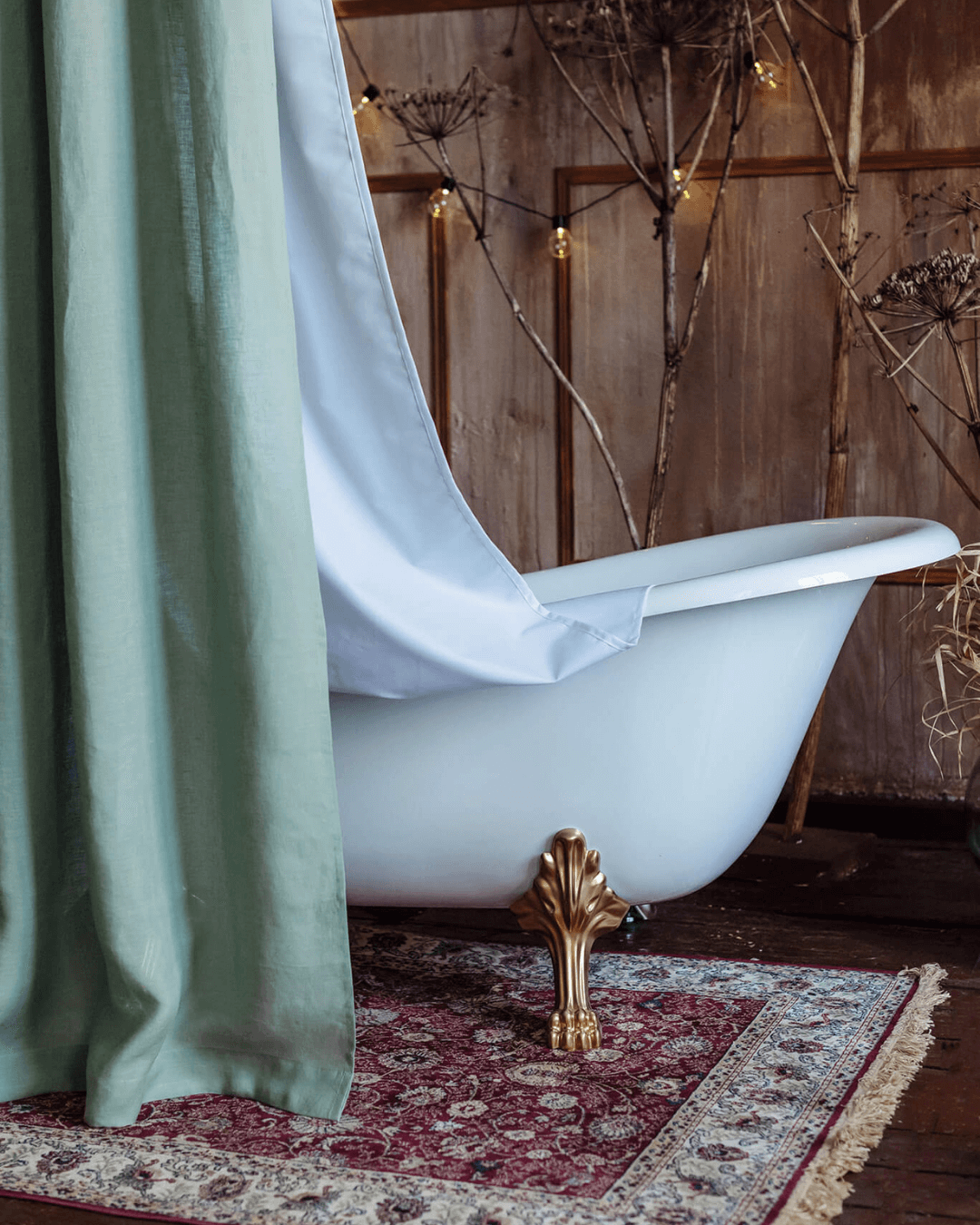 Sage green linen fabric shower curtain beside freestanding bathtub