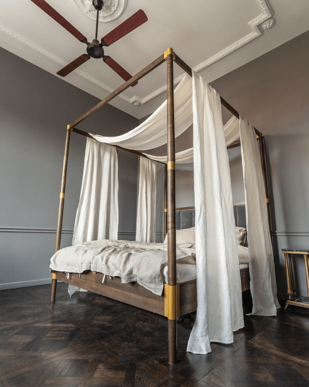 Linen canopy shawl draped over canopy bed, ceiling fan interior setting
