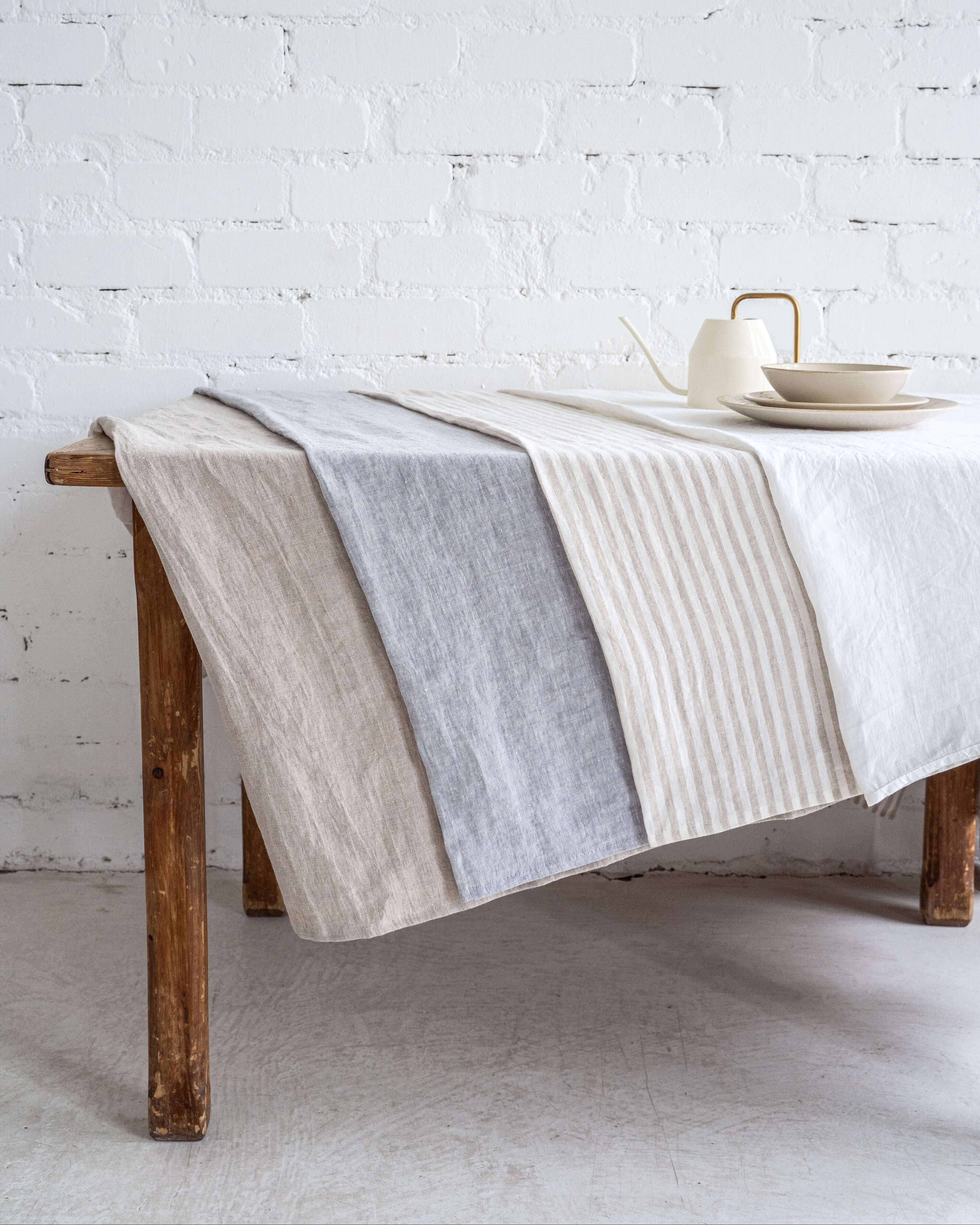 Linen tablecloth with tableware styled on wooden dining table