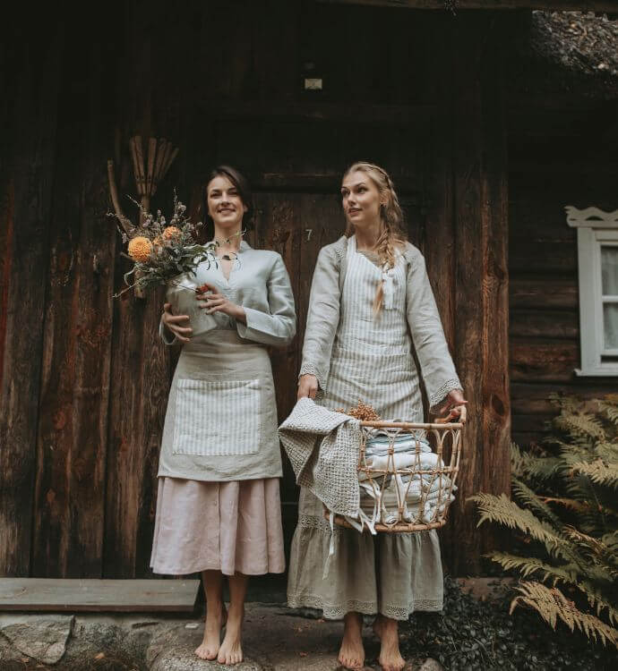 Two people in white linen outfits standing outdoors