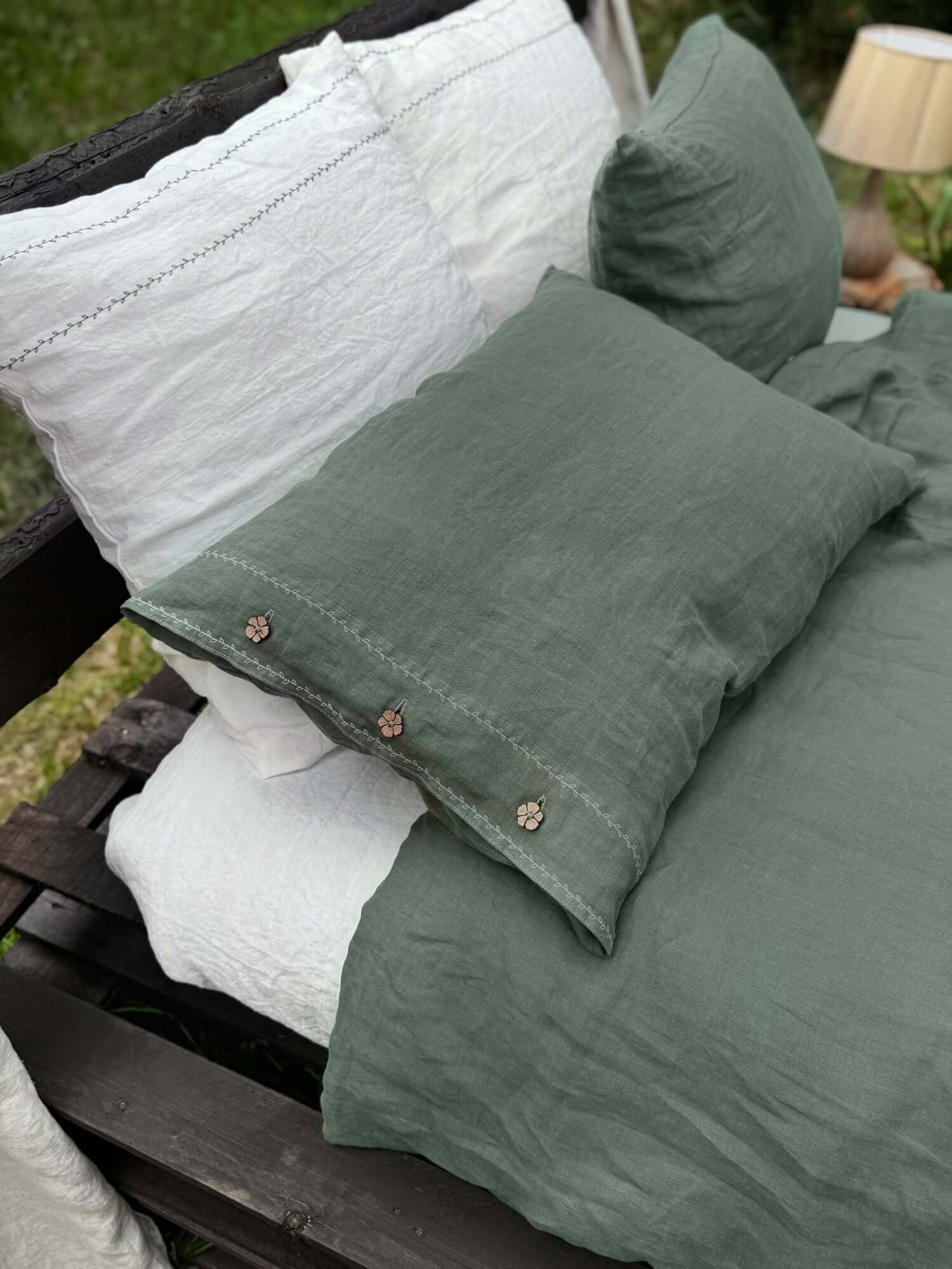 White embroidered linen pillowcase styled in soft neutral bedroom setting