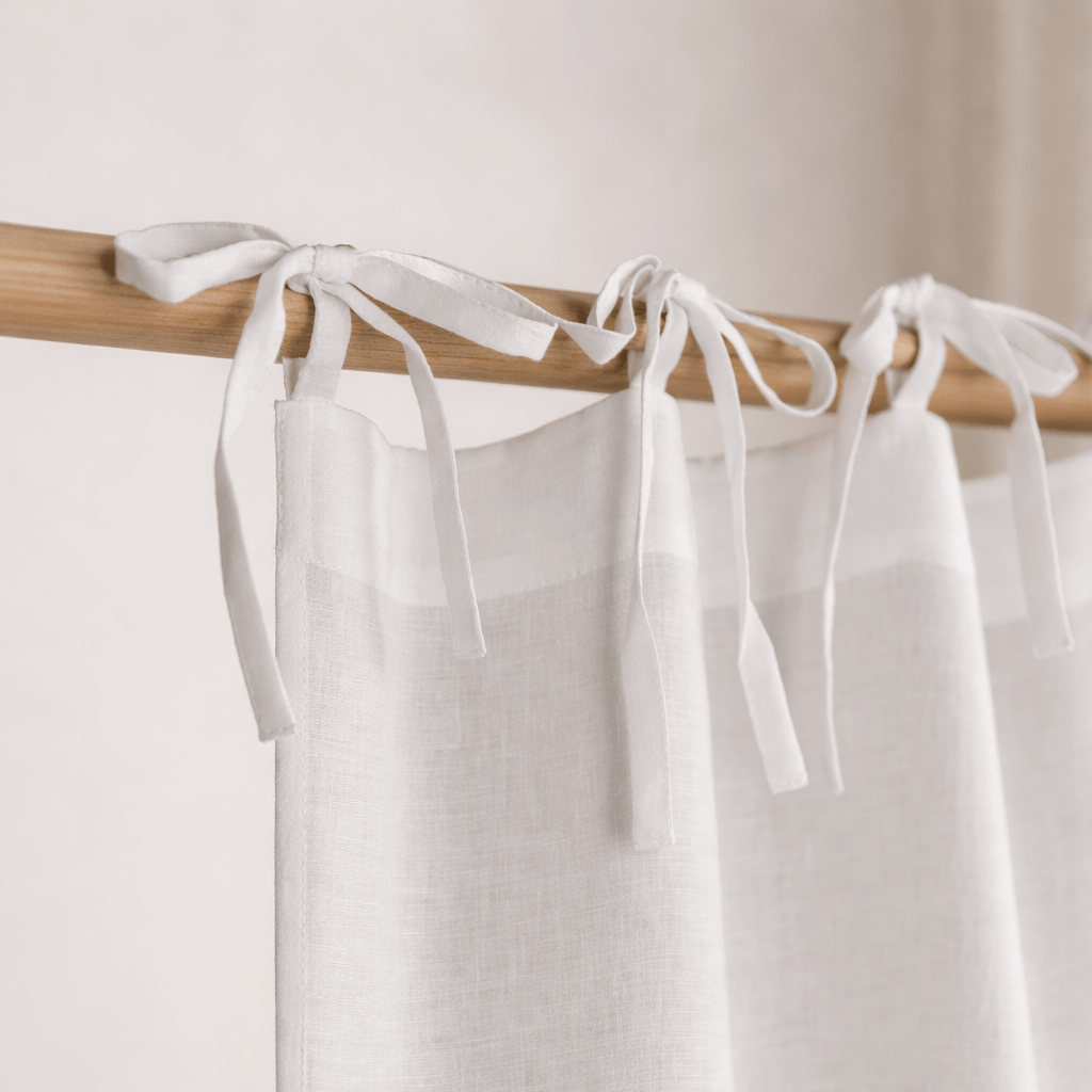 Close-up of white linen curtain with ties top finish