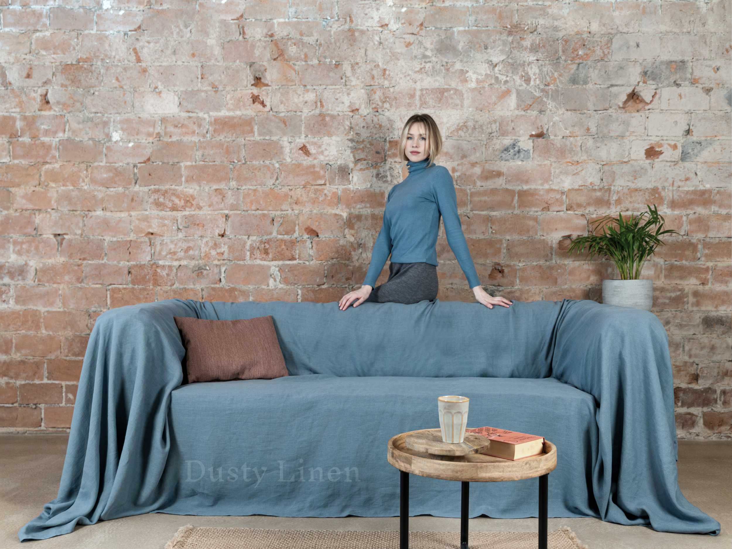 a woman standing on top of a blue couch