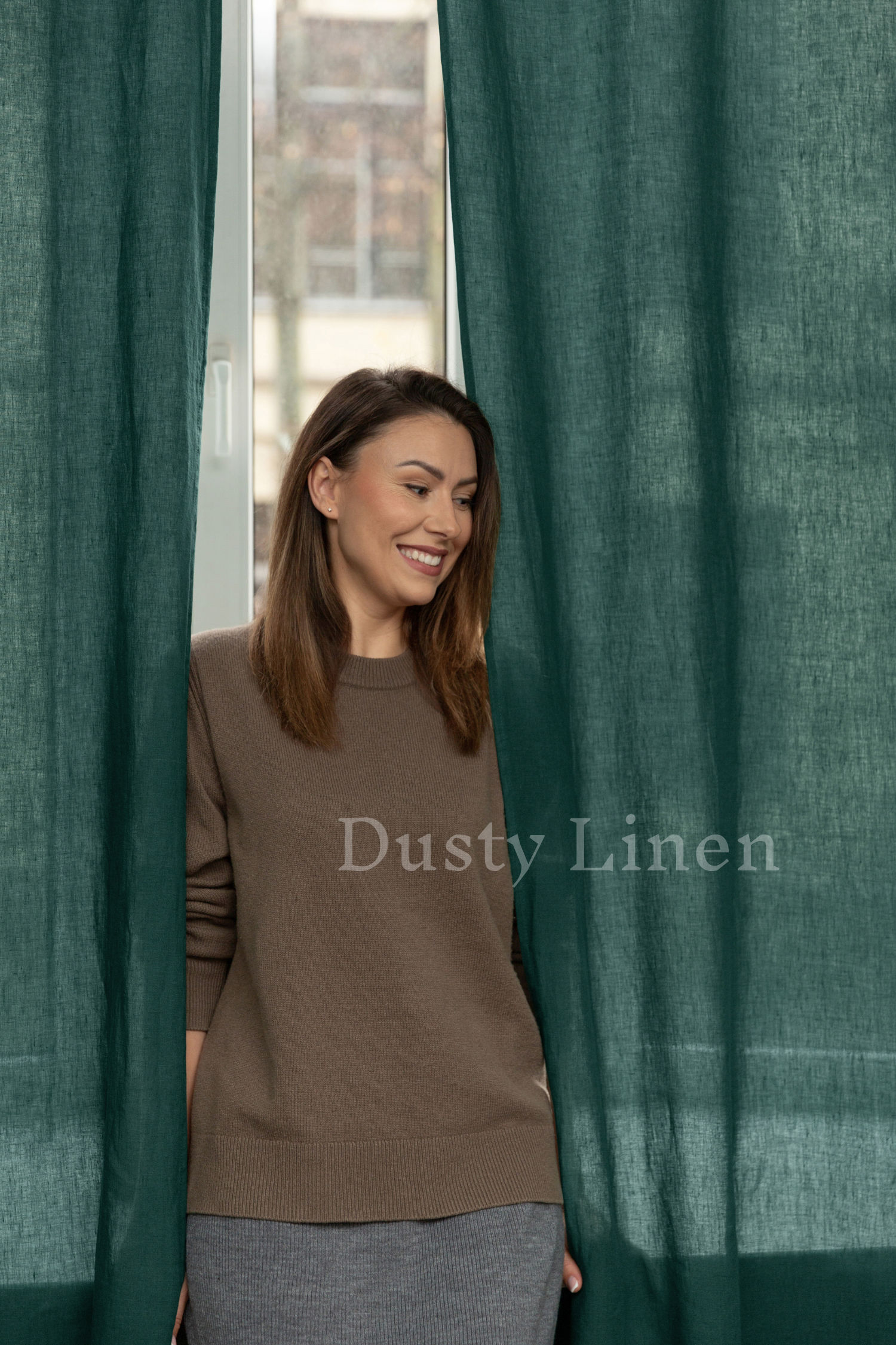 a woman standing in front of a green curtain