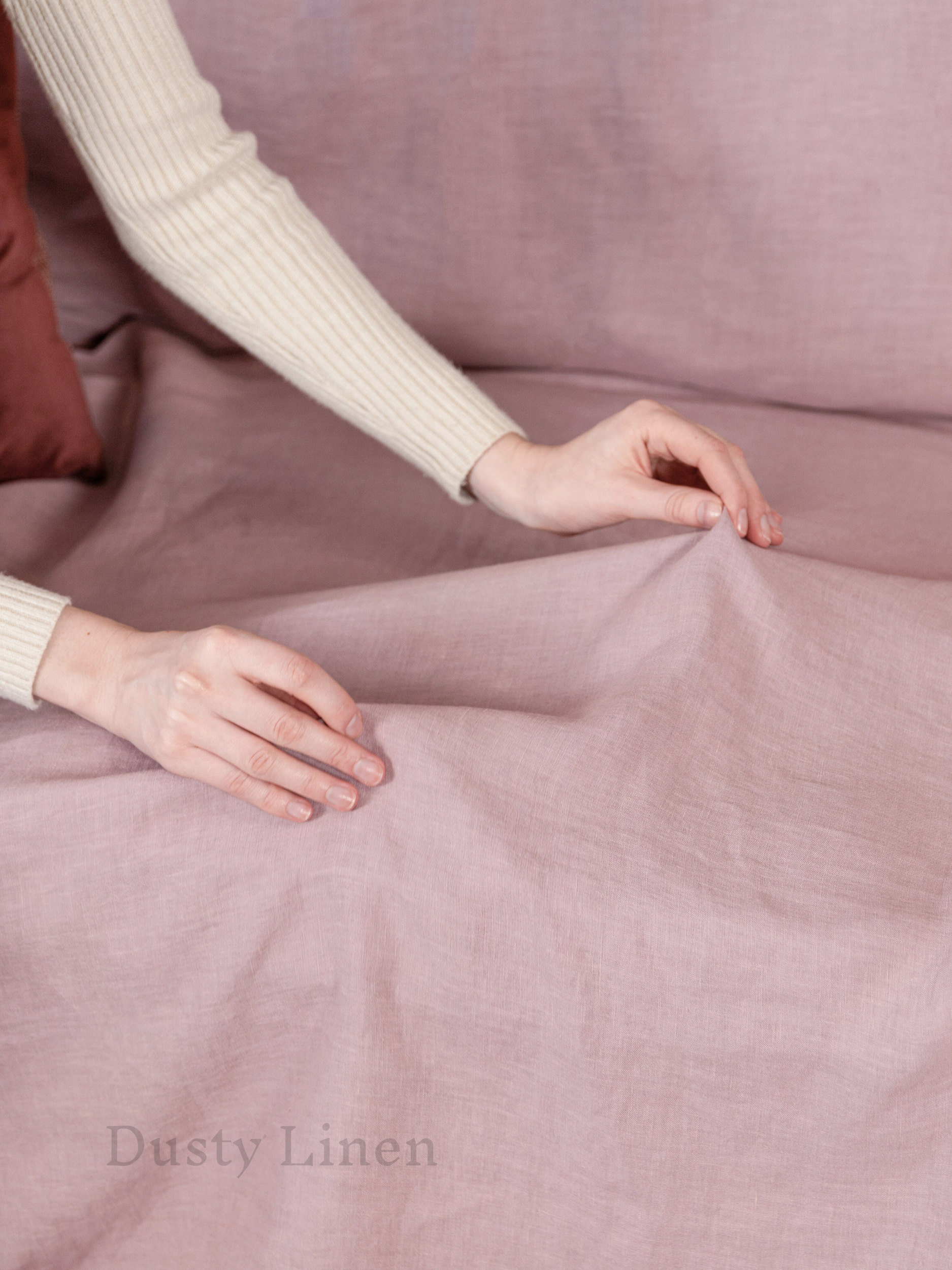 a woman is laying on a bed with a pink sheet