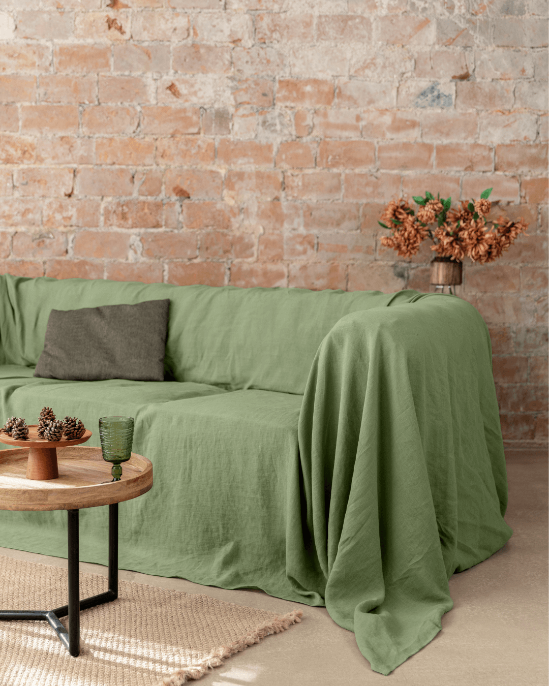 a living room with a brick wall and a green couch