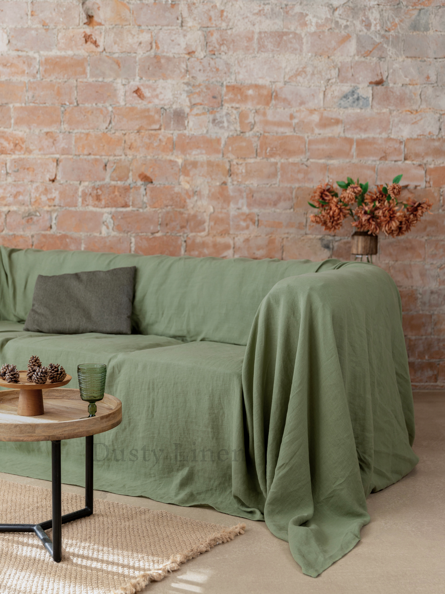 a living room with a brick wall and a green couch