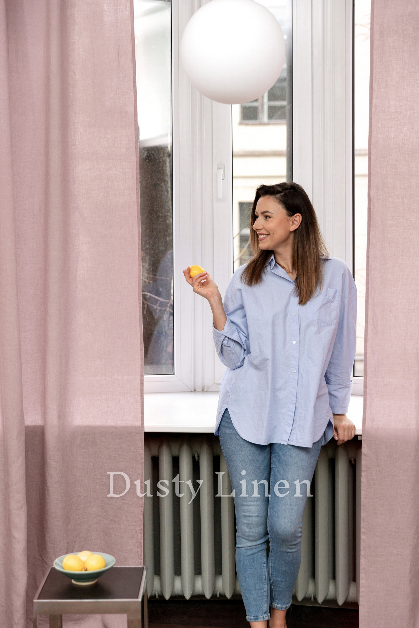 a woman standing in front of a window holding a piece of food