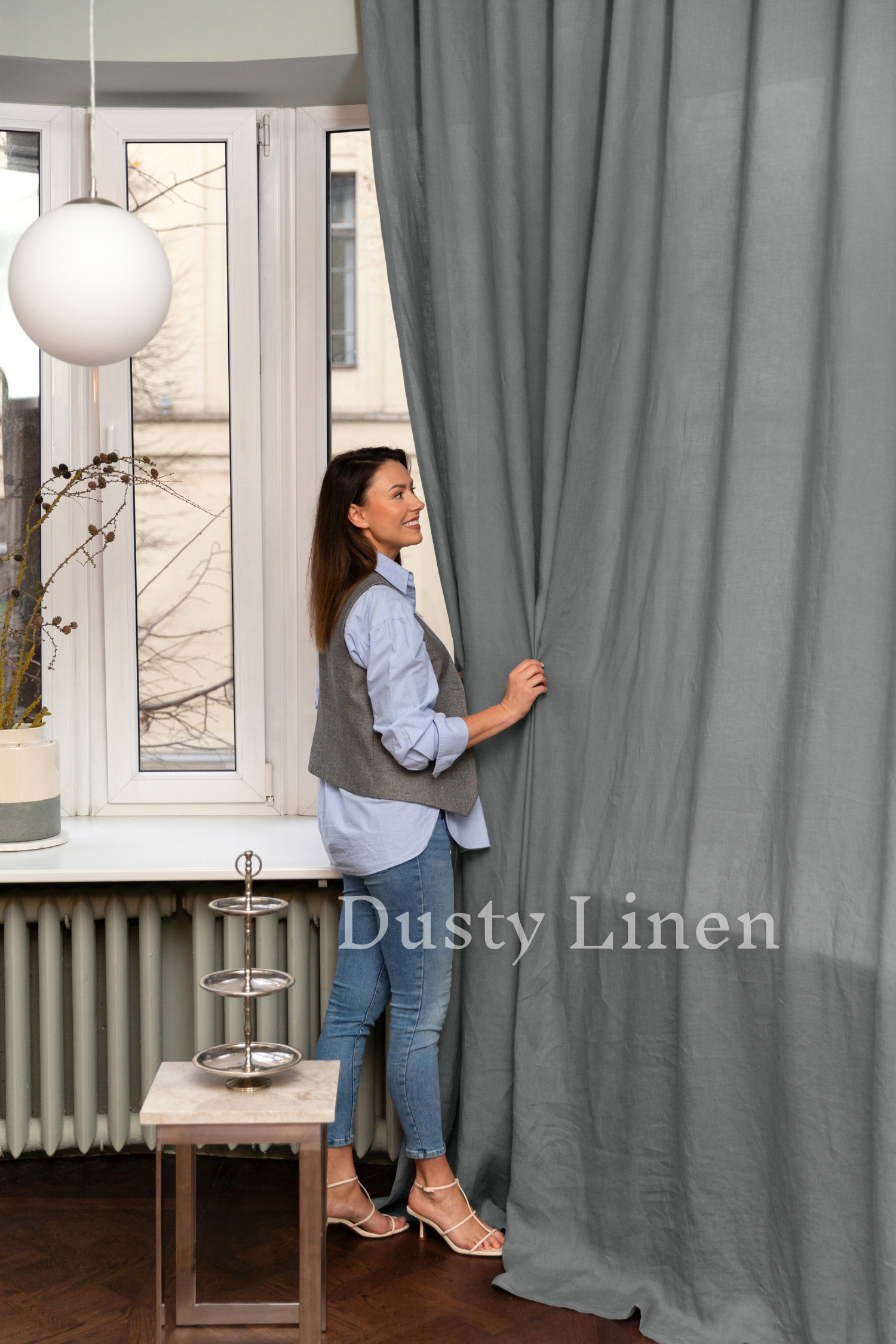 a woman standing behind a curtain in front of a window