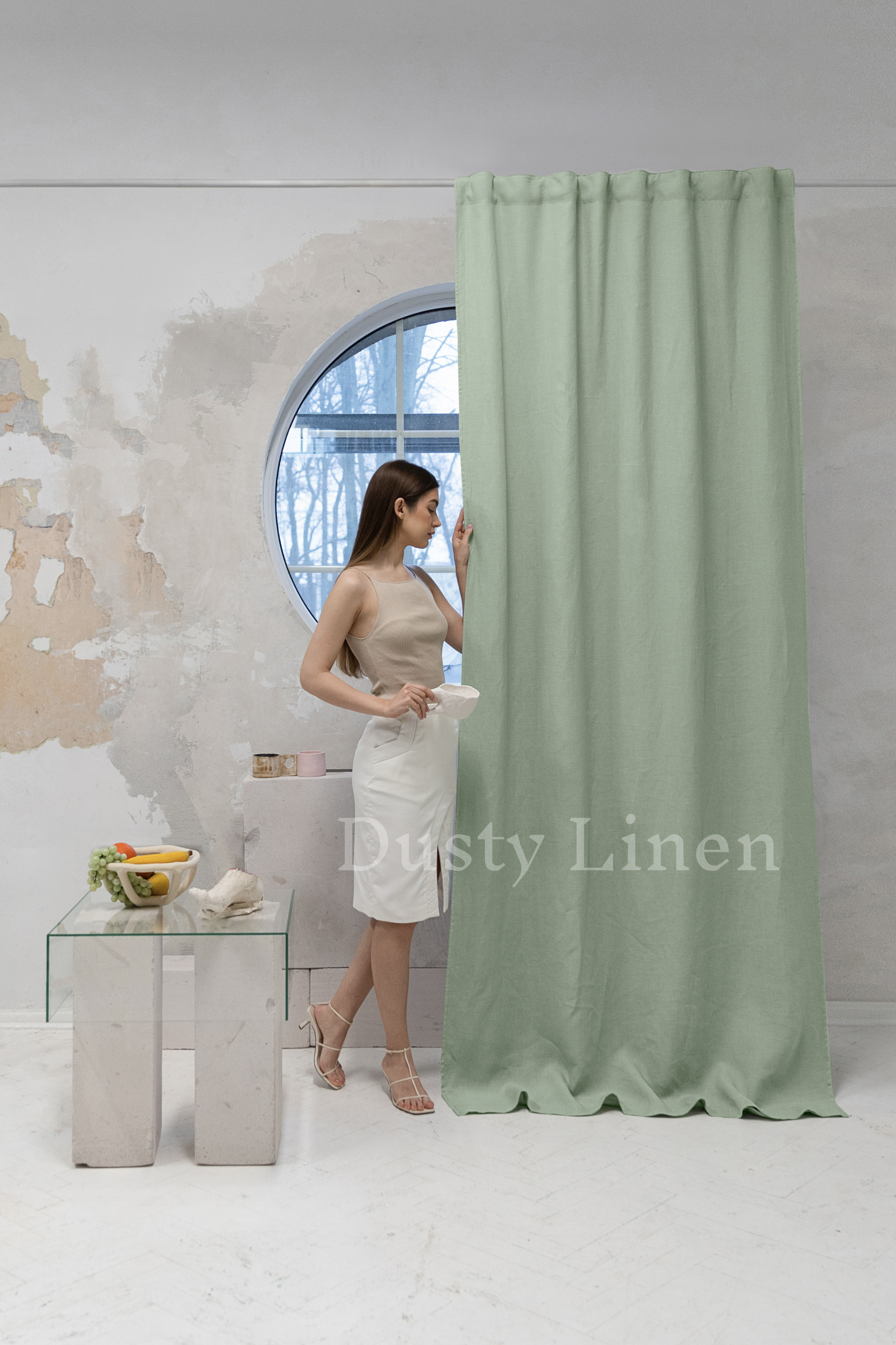 a woman standing in front of a green curtain