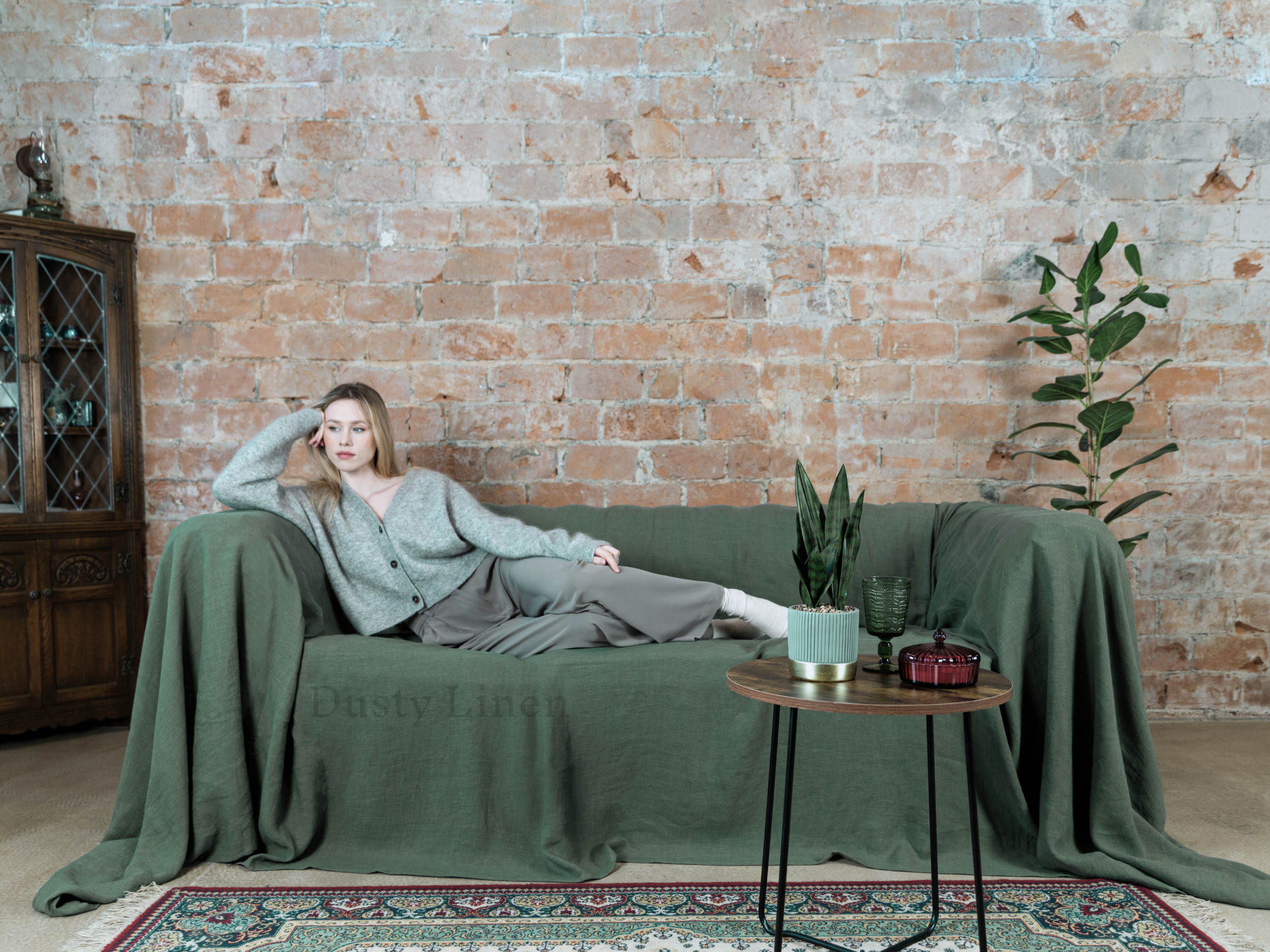 a woman sitting on a green couch in a living room