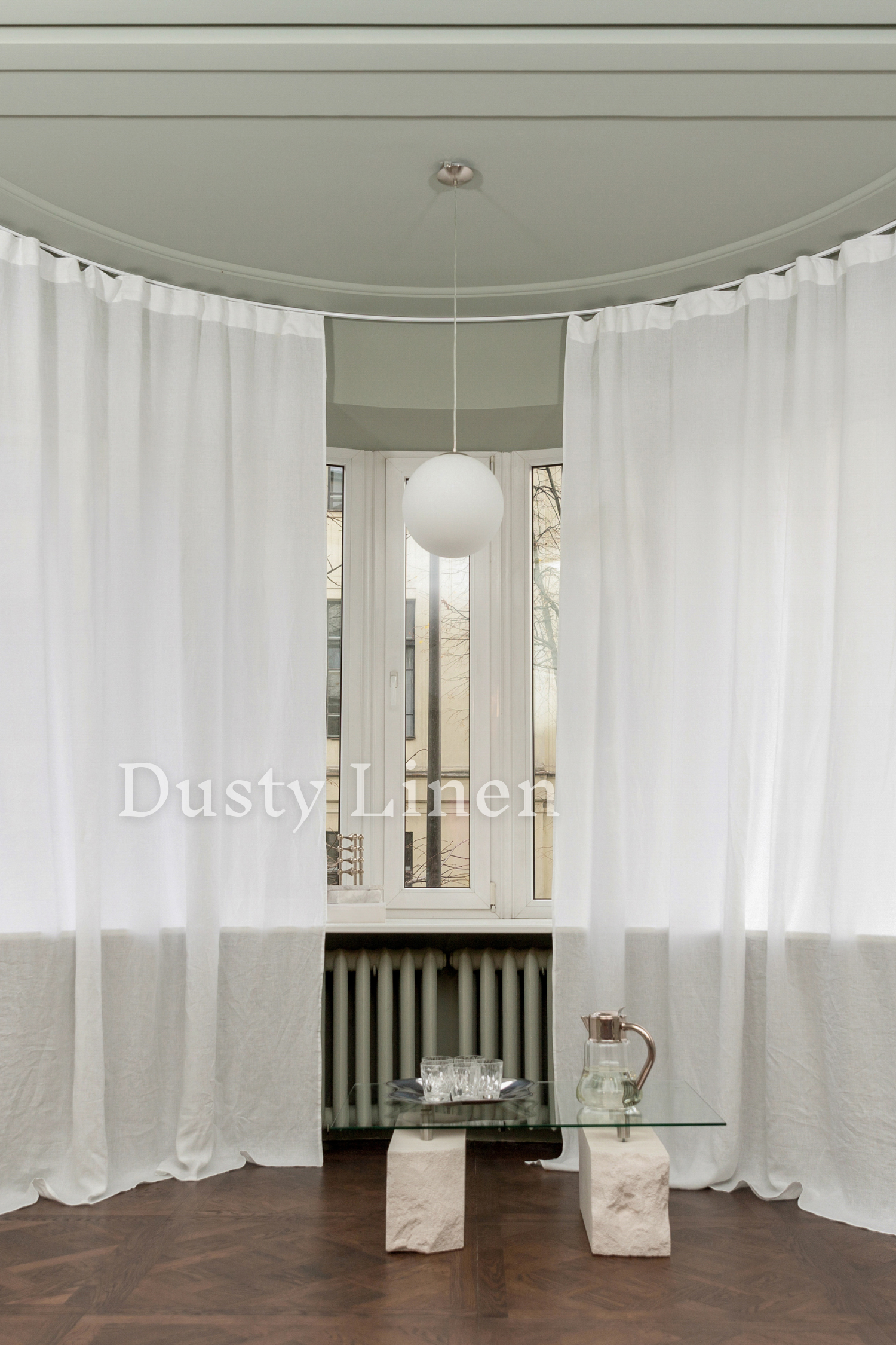 a living room with white curtains and a glass table