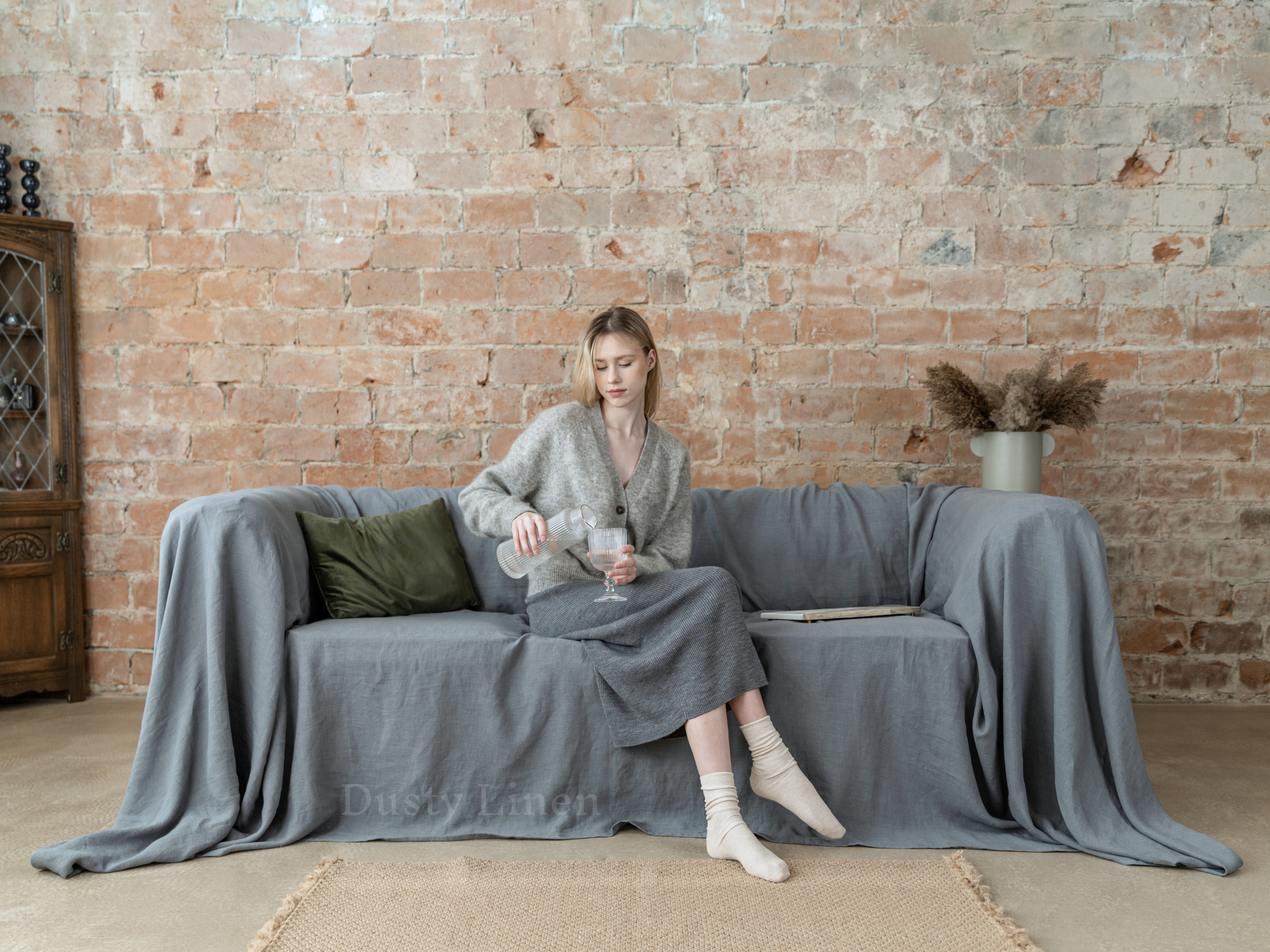 a woman sitting on a couch with a blanket on it